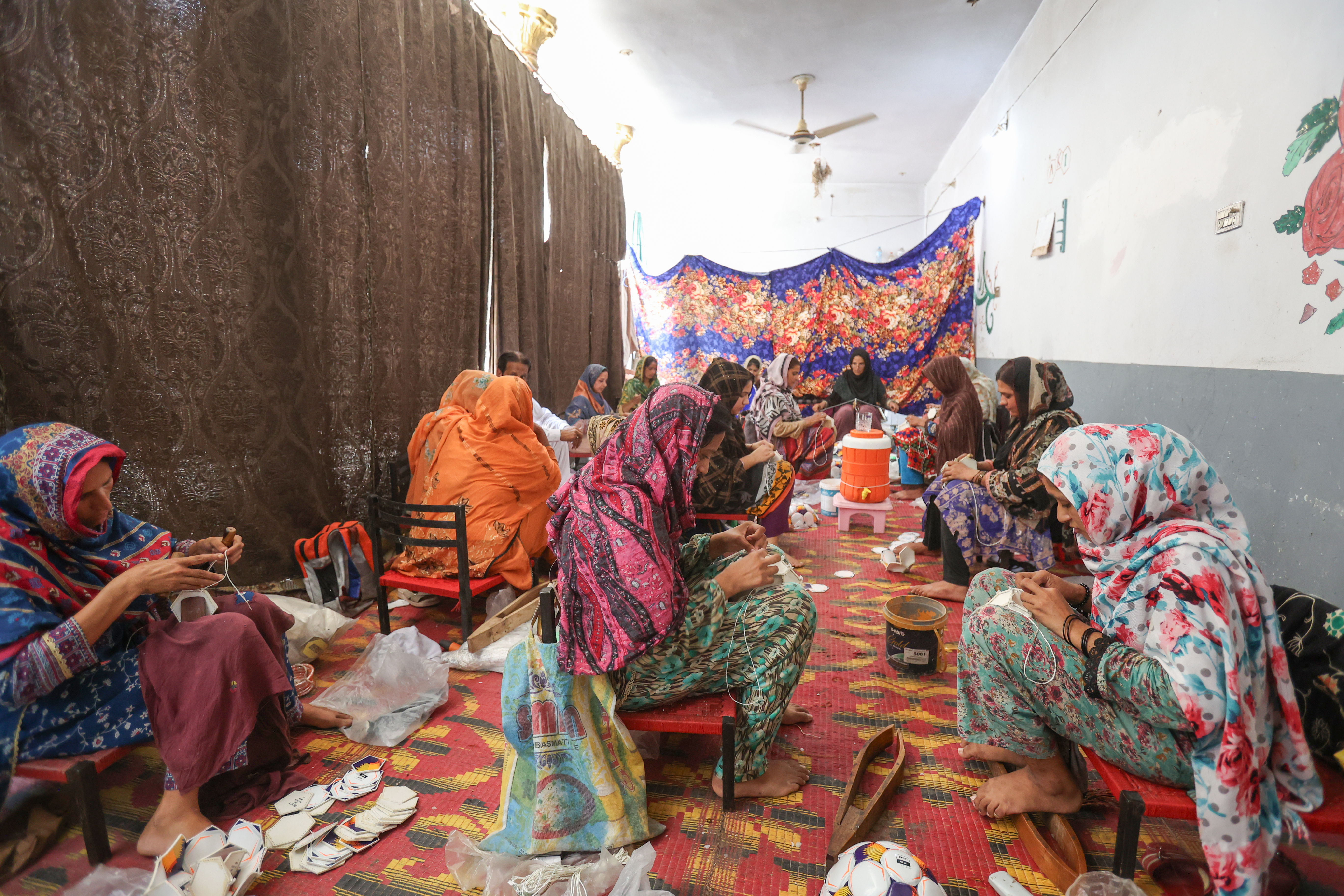 Women stitch footballs together in Pakistan