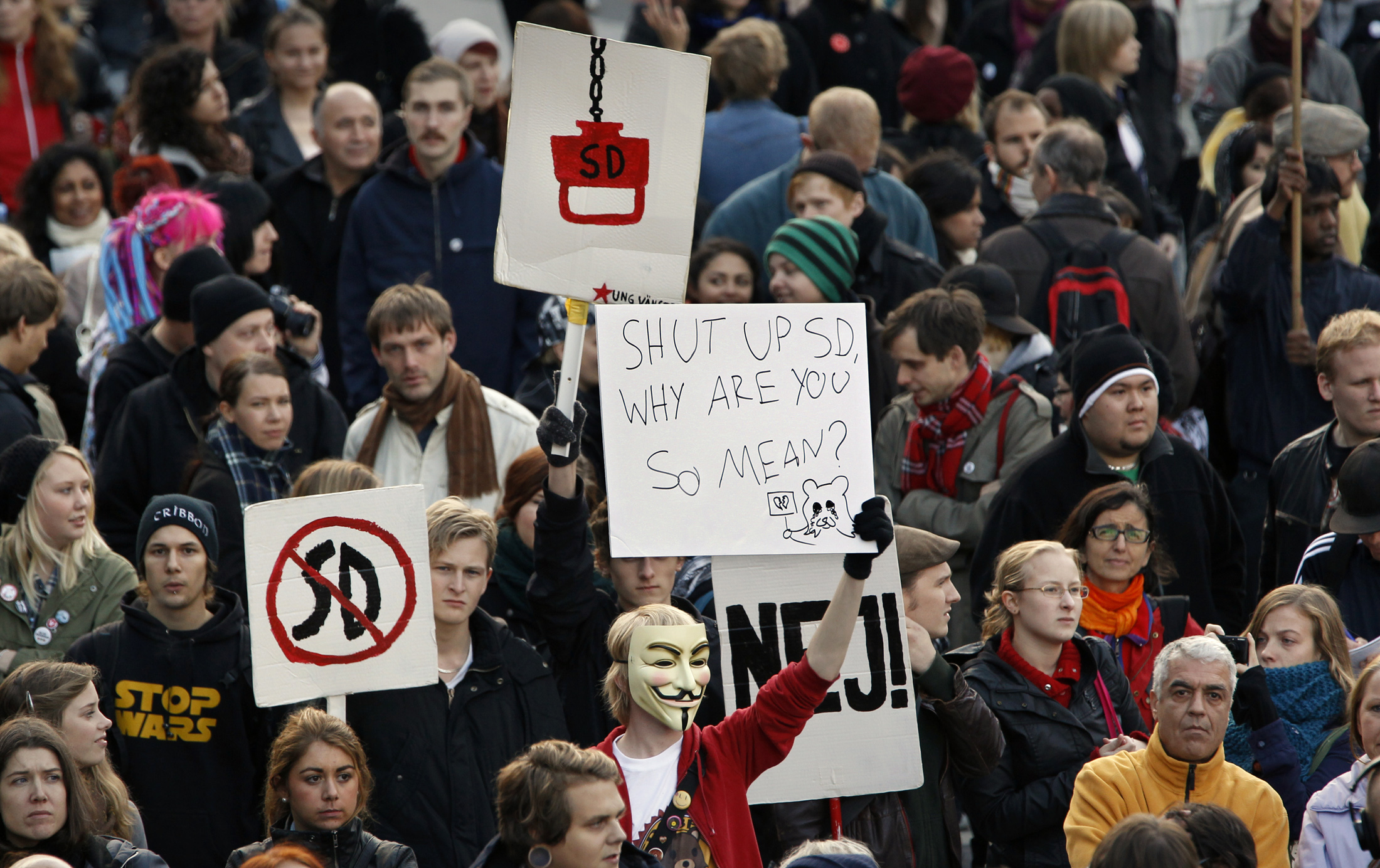 Protesters carry signs against the SD party during a demonstration against anti-immigration politics in Stockholm, October 4, 2010