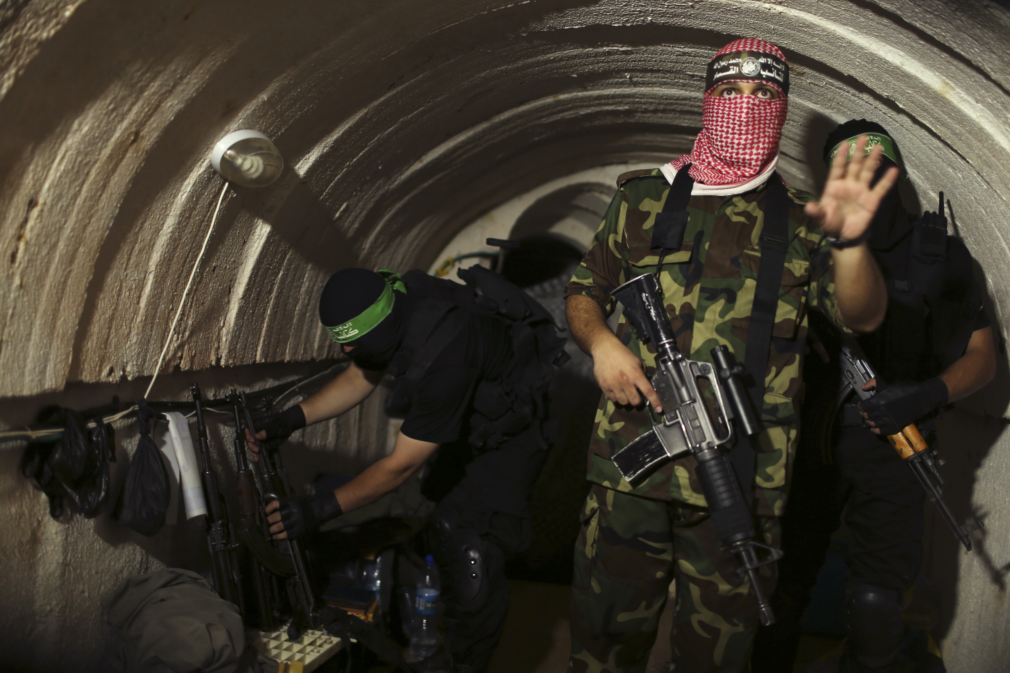 A Palestinian fighter from the Izz el-Deen al-Qassam Brigades, the armed wing of the Hamas movement, gestures inside an underground tunnel in Gaza August 18, 2014. A rare tour that Hamas granted to a Reuters reporter, photographer and cameraman appeared to be an attempt to dispute Israel's claim that it had demolished all of the Islamist group's border infiltration tunnels in the Gaza war. Picture taken August 18, 2014. REUTERS/Mohammed Salem (GAZA - Tags: POLITICS CONFLICT TPX IMAGES OF THE DAY)