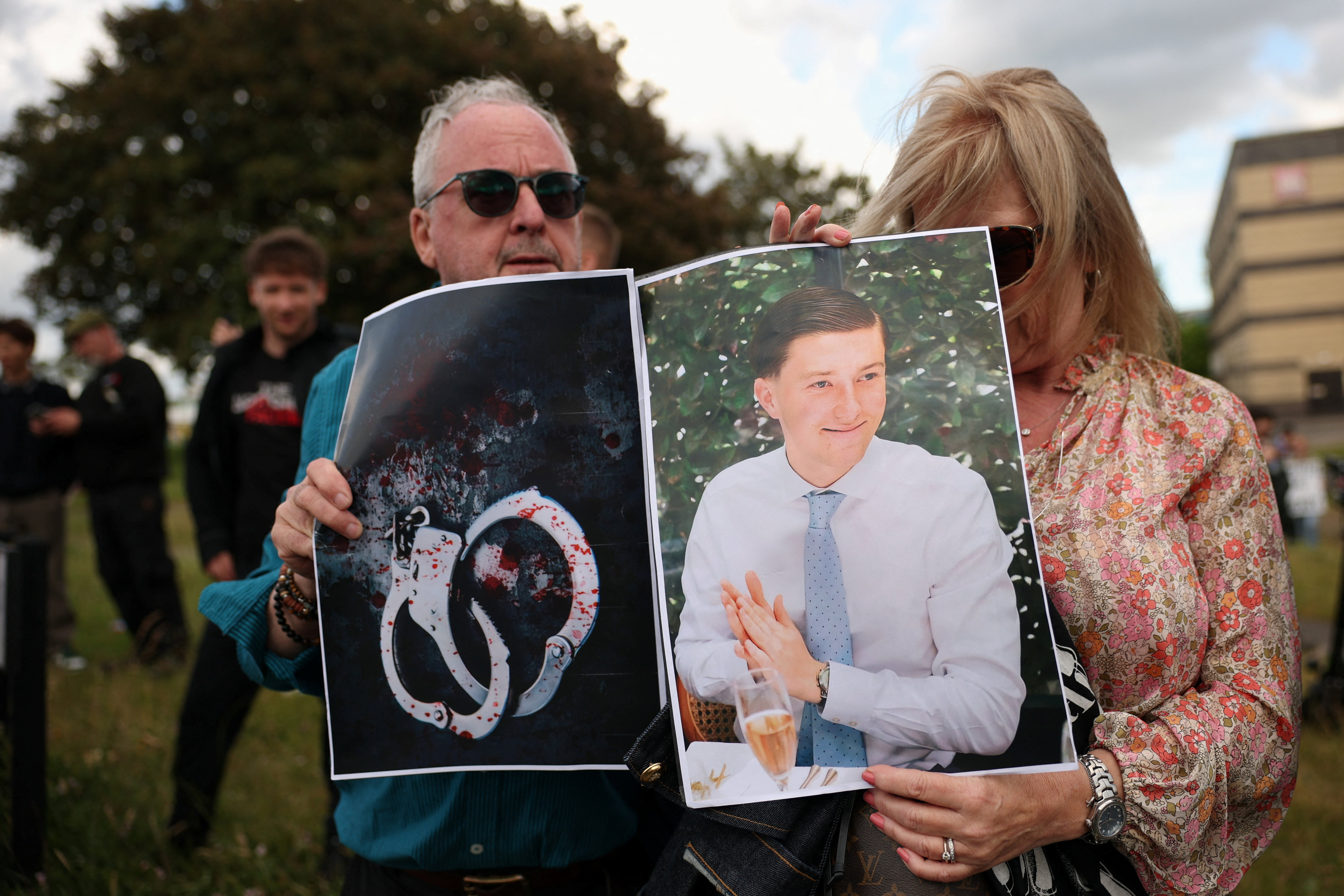 Demonstrators hold two pictures, one of Henry Nowak and another of handcuffs, during a protest outside Southampton Central Police Station following the conviction of Vikrum Digwa for the murder of student Henry Nowak, in Southampton, Britain, June 2, 2026. REUTERS/Isabel Infantes