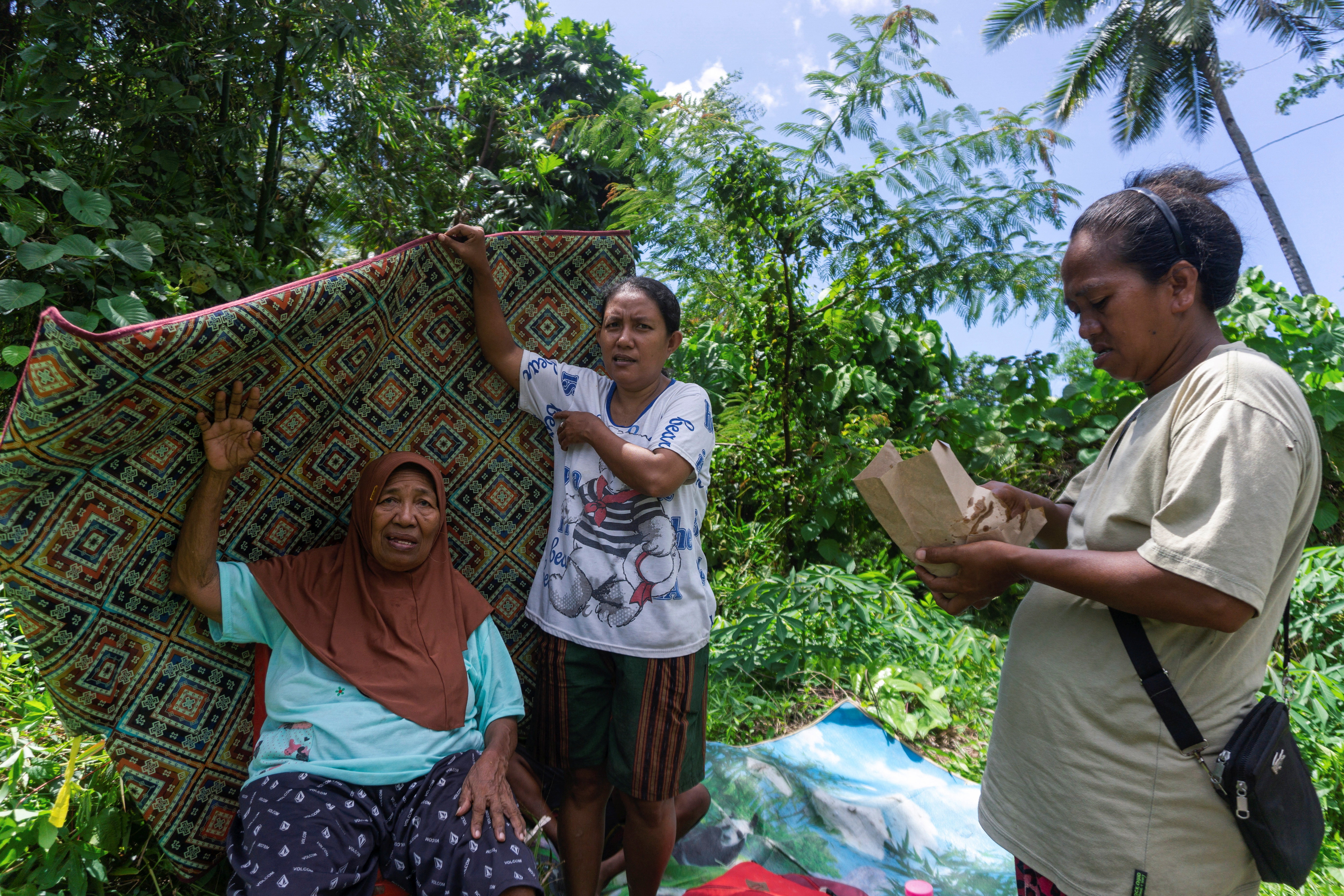 People carry their belongings during evacuation following an earthquake off the southern Philippine island of Mindanao that was also felt in North Tabukan, Sangihe Islands regency, North Sulawesi province, Indonesia, June 8, 2026. REUTERS/Stenly Pontolawokang