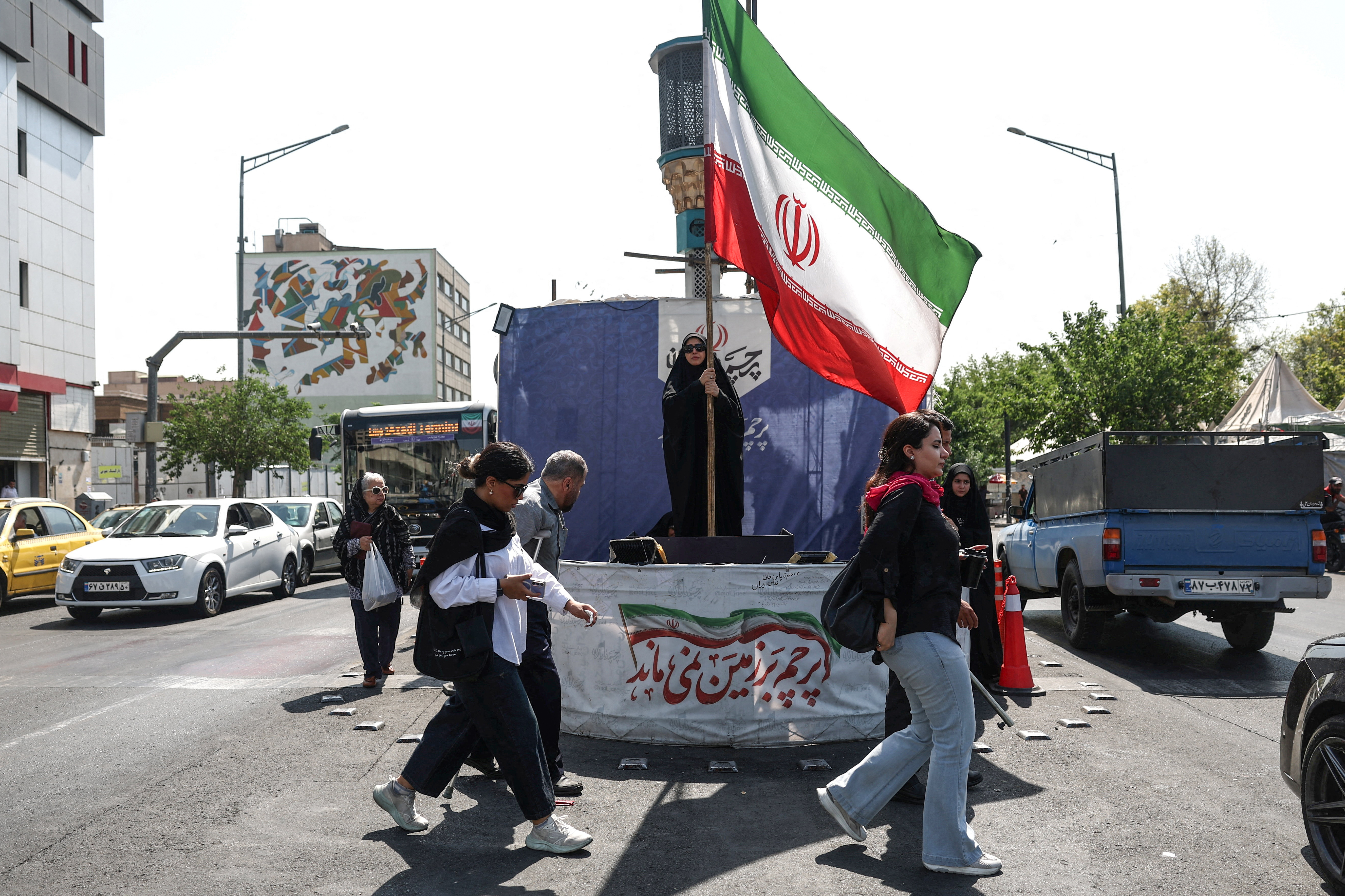 A woman holds an Iranian flag on a street in Tehran, Iran
