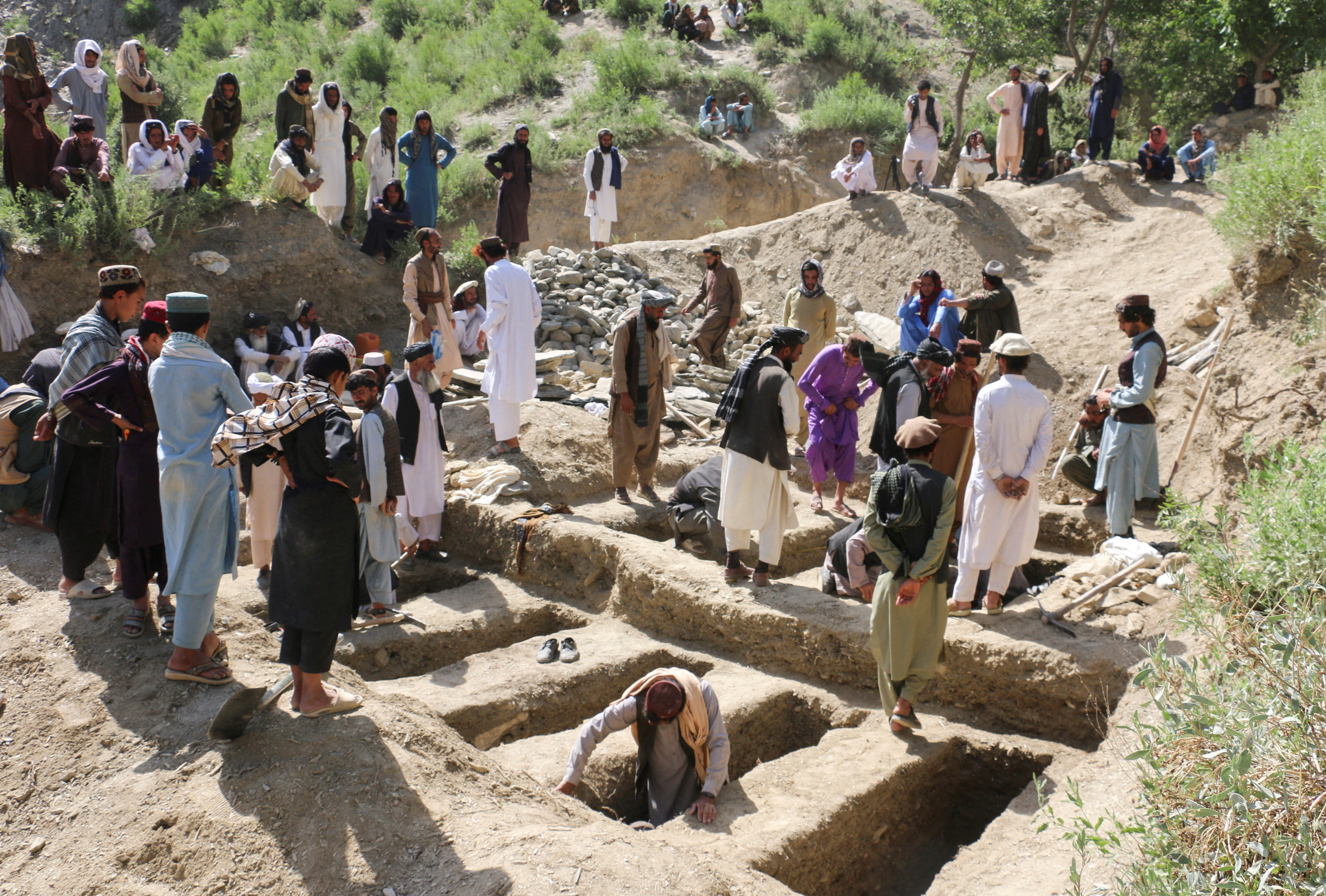 People dig graves for victims who died in what the Taliban said was a Pakistani airstrike in Mani village,