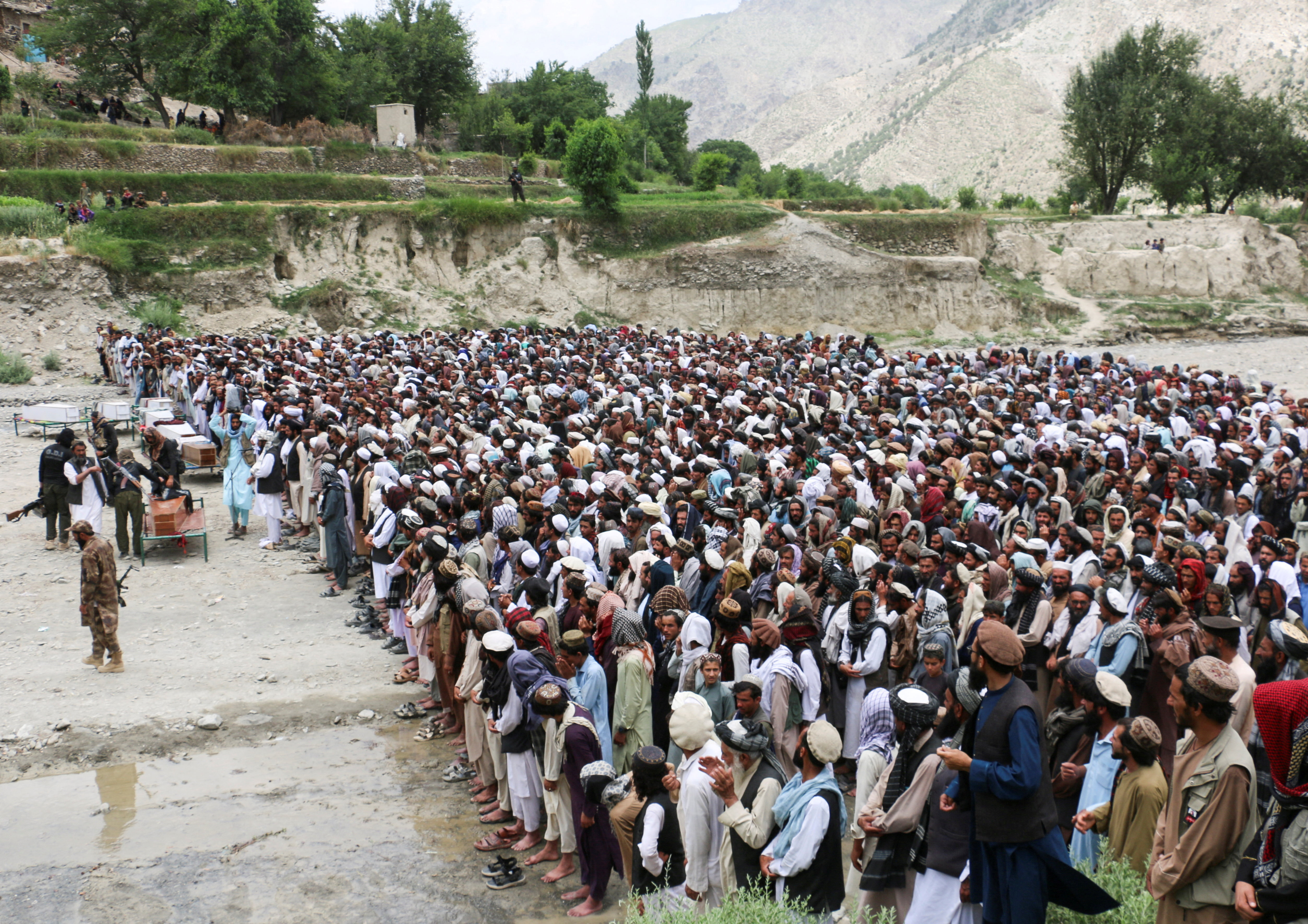 People offer funeral prayers as they gather near coffins containing the bodies of victims who died in what the Taliban said was a Pakistani airstrike in Mani village, Spera District, Khost Province,