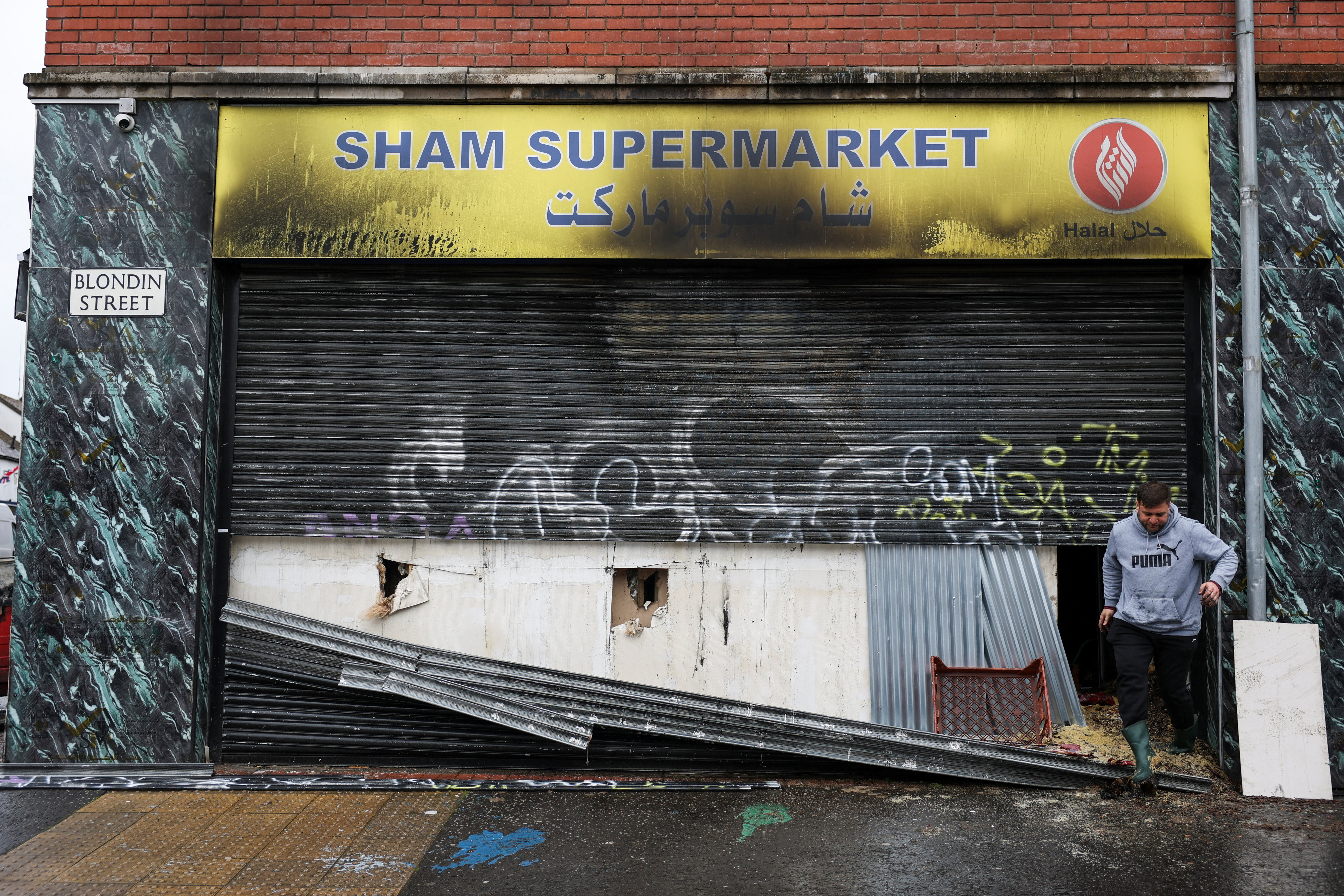 A man inspects the damage to a burned supermarket.