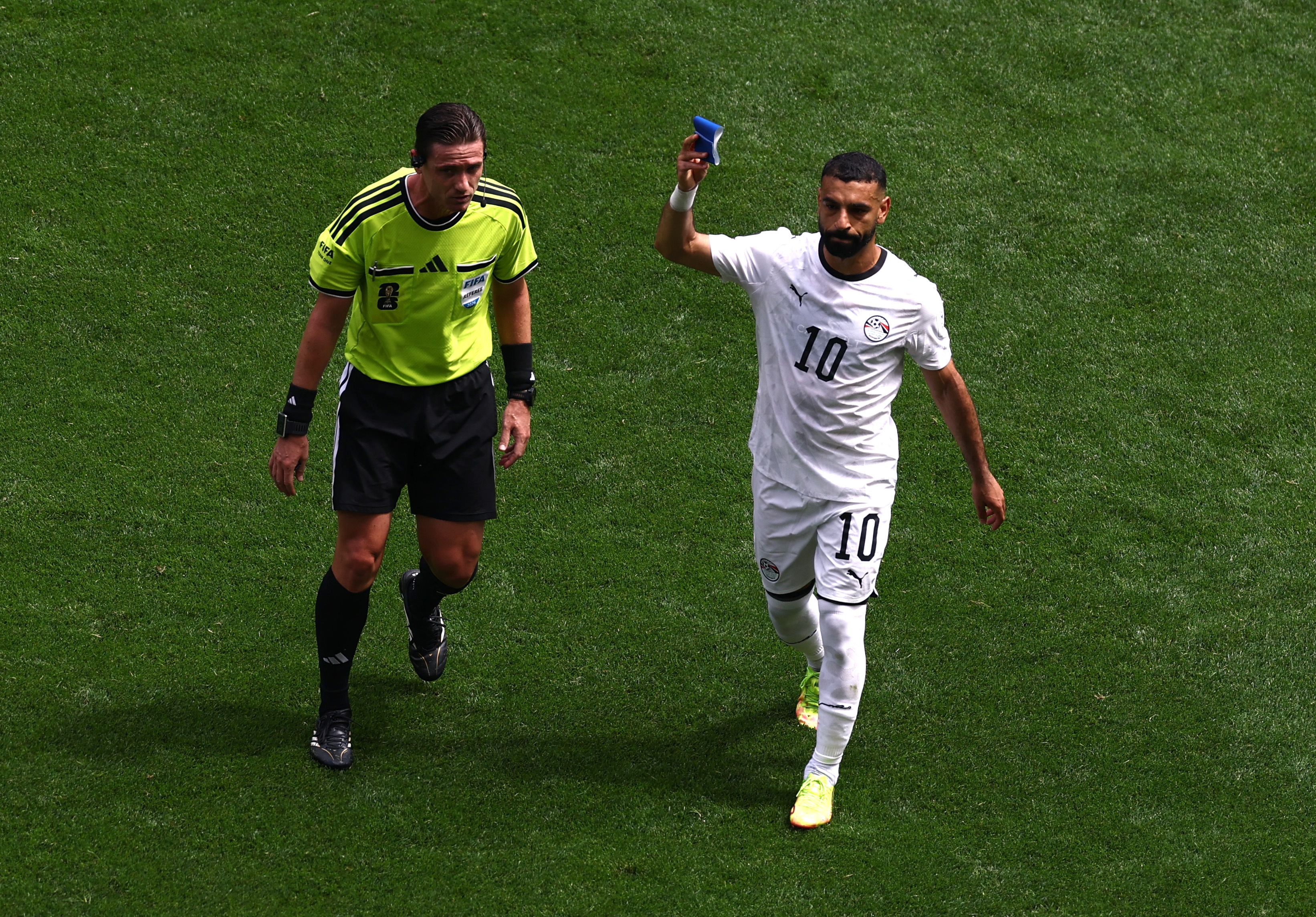 Soccer Football - FIFA World Cup 2026 - Group G - Belgium v Egypt - Seattle Stadium, Seattle, Washington, U.S. - June 15, 2026 Egypt's Mohamed Salah holds up the captains armband as he is substituted as referee Ramon Abatti looks on REUTERS/Lee Smith