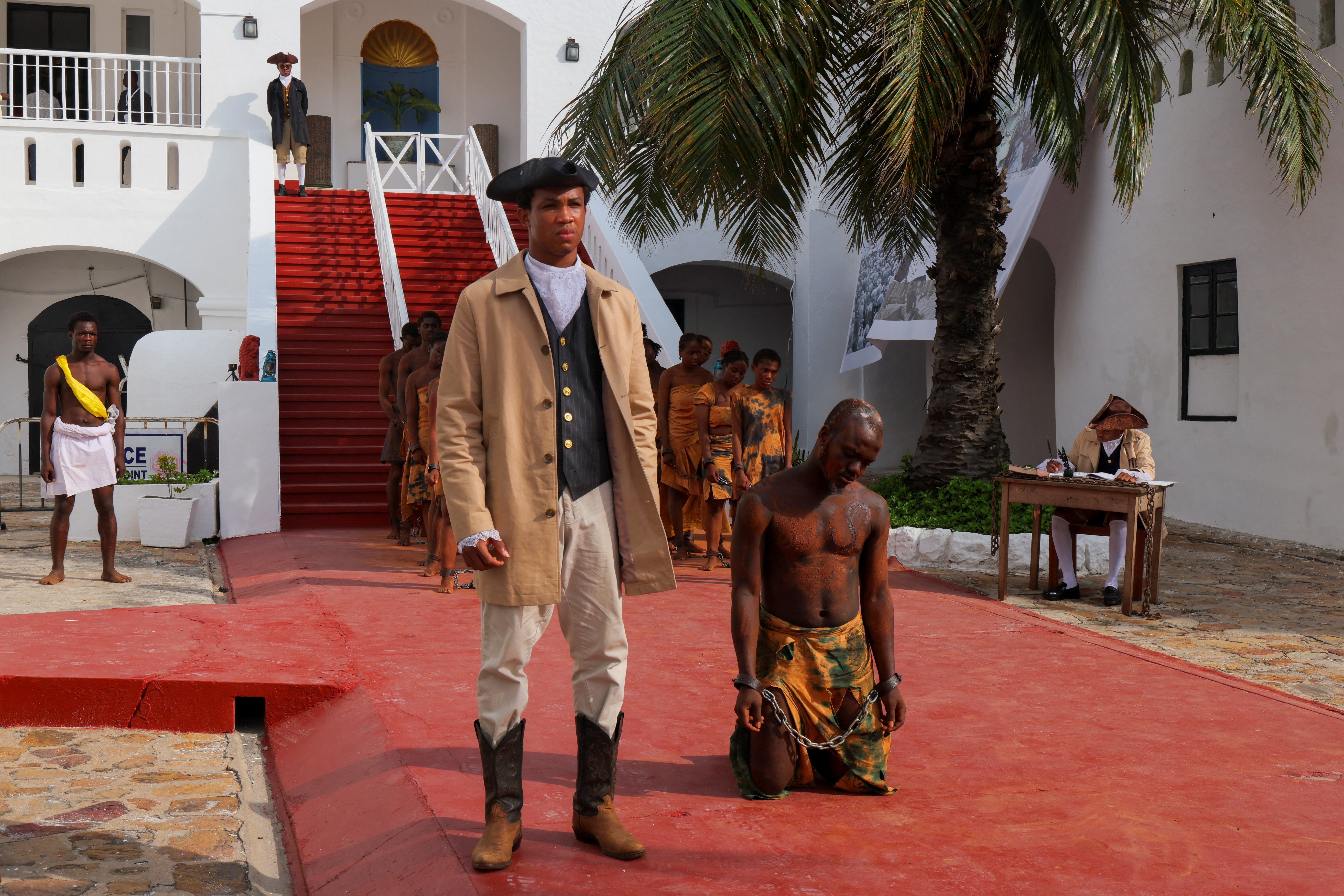 Performers re-enact the transatlantic slave trade at Christiansborg Castle, a former slave post, during a conference on follow-up to a UN resolution on trafficking of enslaved Africans, in Accra, Ghana [/Francis Kokoroko/Reuters]