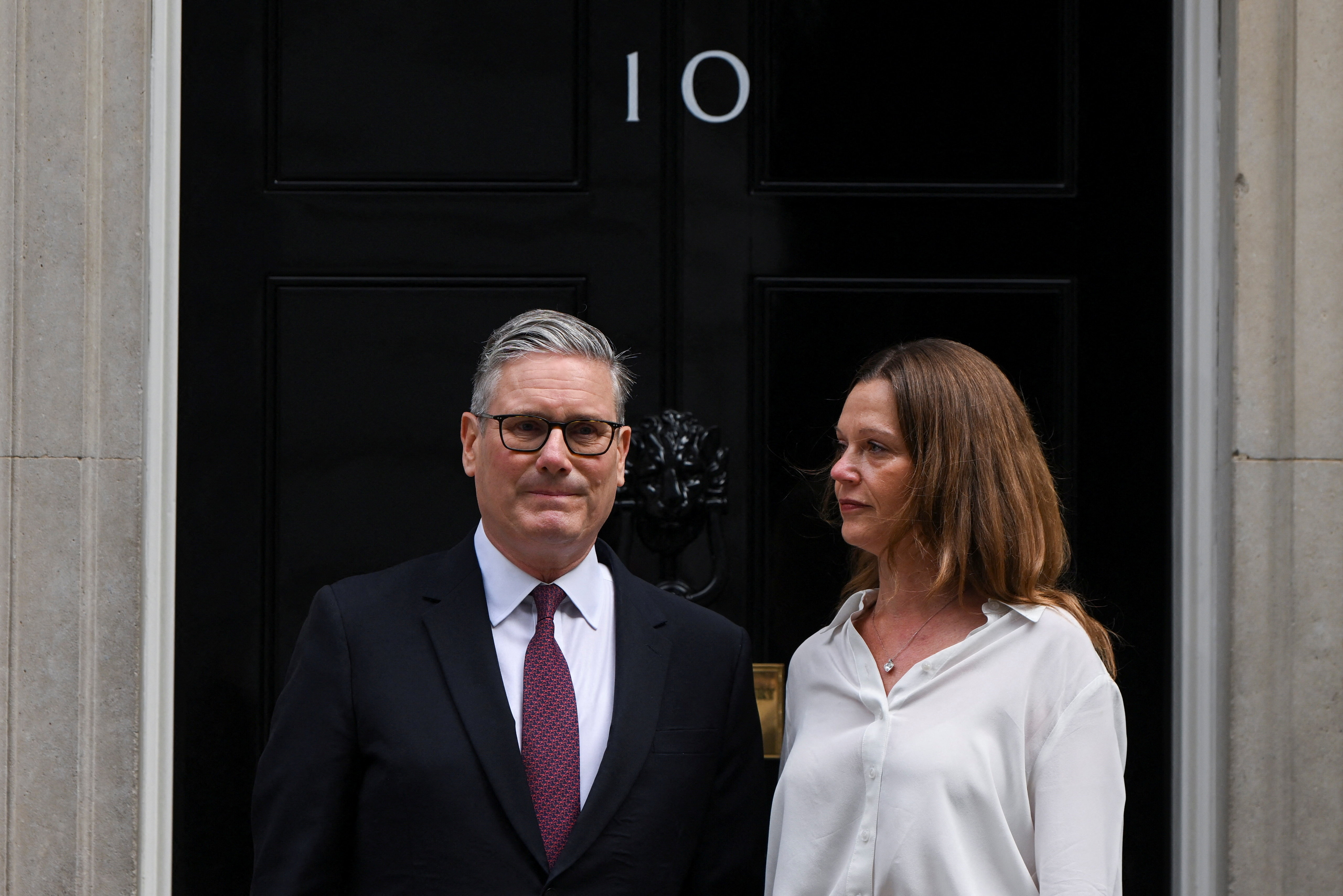 British Prime Minister Keir Starmer stands next to his wife Victoria.