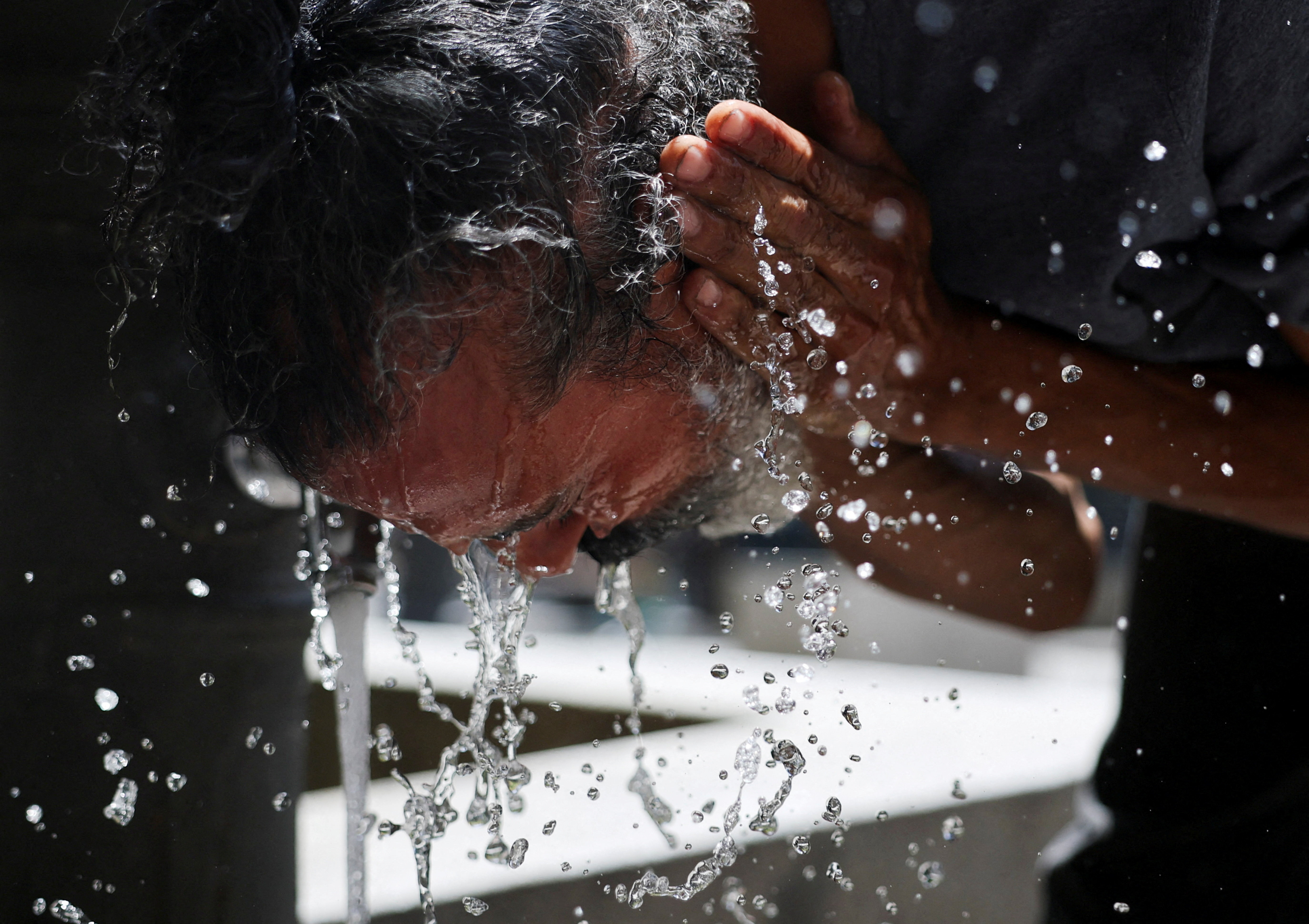 A man washes his face to cool off during a hot day amid a heatwave in Madrid, Spain, June 23, 2026. REUTERS/Mohammed Salem TPX IMAGES OF THE DAY