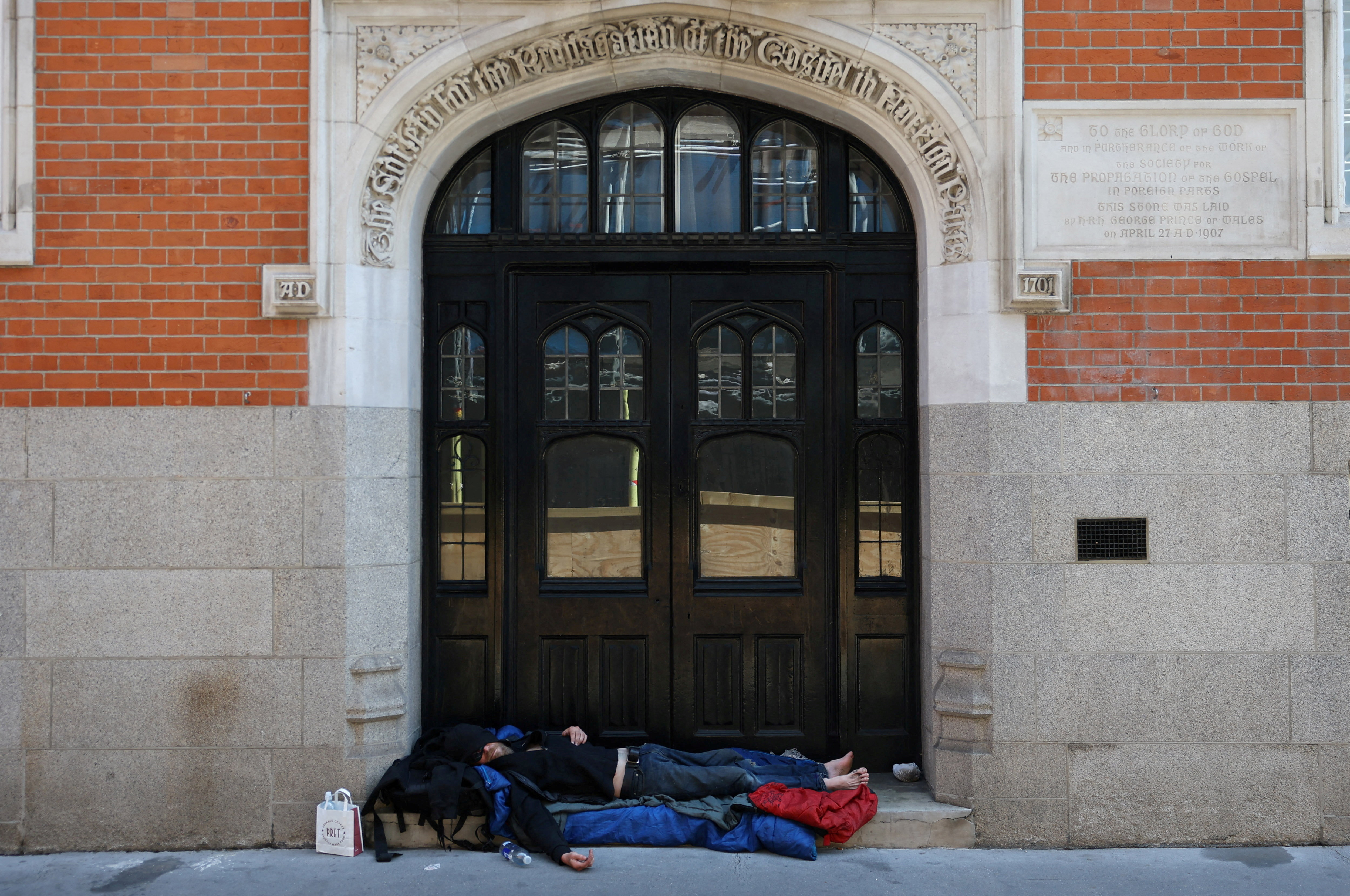 A homeless person sleeps in a shaded doorway, as Britain experiences record temperatures disrupting schools and transport networks, at Waterloo Station in London, Britain, June 24, 2026. REUTERS/Toby Melville TPX IMAGES OF THE DAY