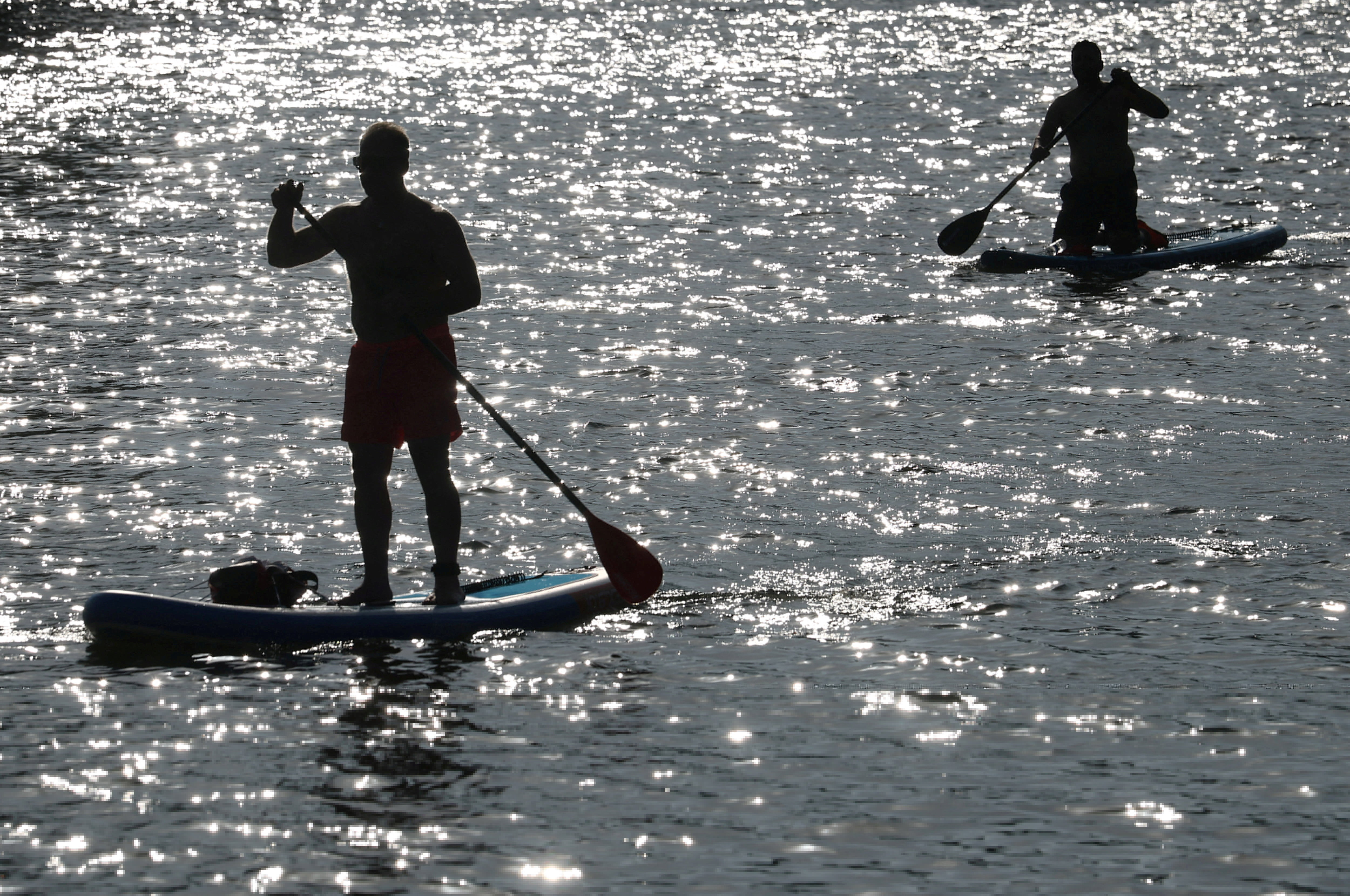 People ride paddle boards along the River Thames as Britain experiences record temperatures that disrupt schools and transport networks, at Richmond, London, Britain, June 25, 2026. REUTERS/Toby Melville TPX IMAGES OF THE DAY