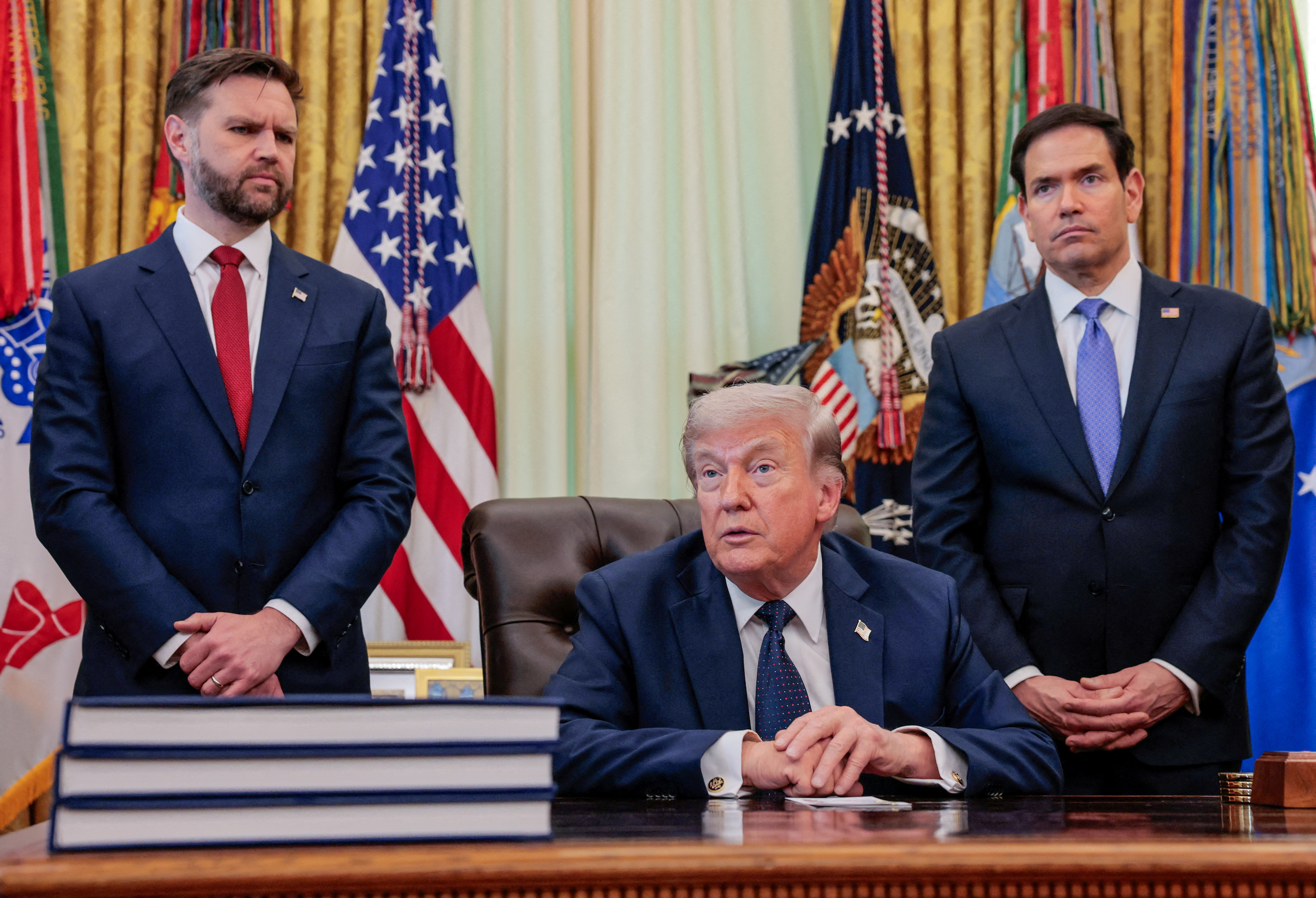 US President Donald Trump speaks in the Oval Office, with Vice President JD Vance and Secretary of State Marco Rubio standing behind him, at the White House in Washington, D.C