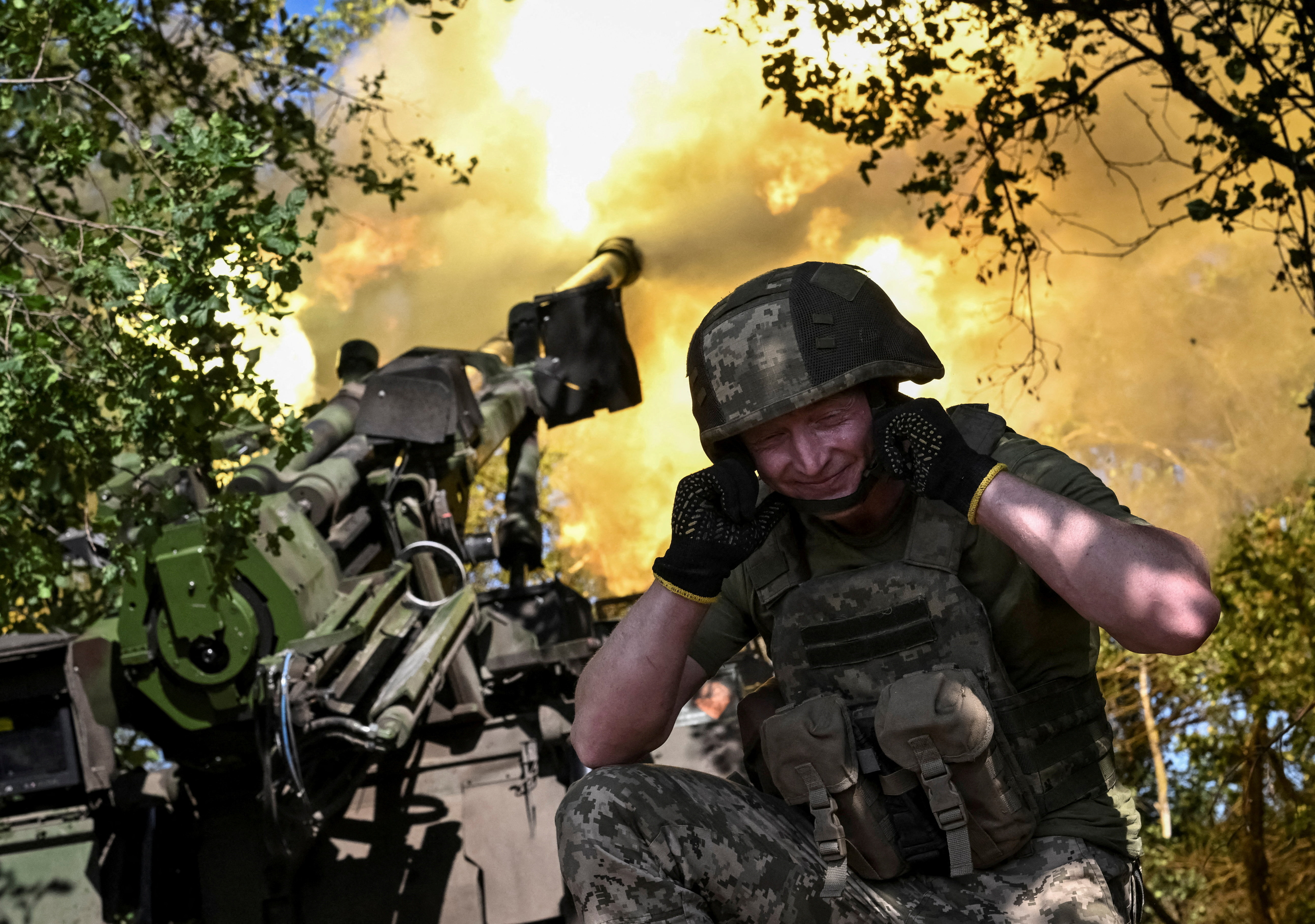 A serviceman fires a howitzer.