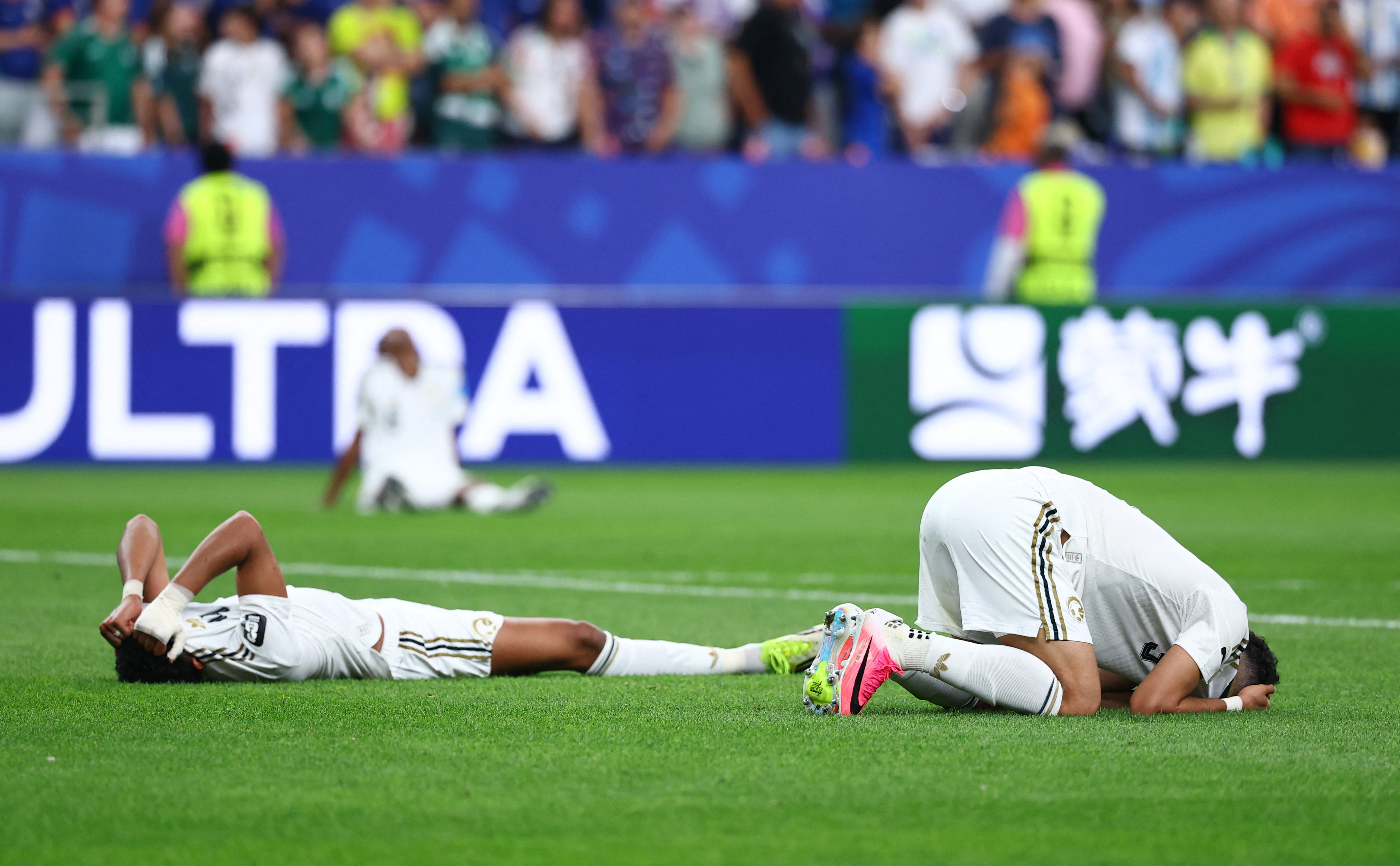 Abdulelah Al-Amri and Ali Lajami look dejected after the match as Saudi Arabia are eliminated from the World Cup [Pedro Nunes/Reuters]