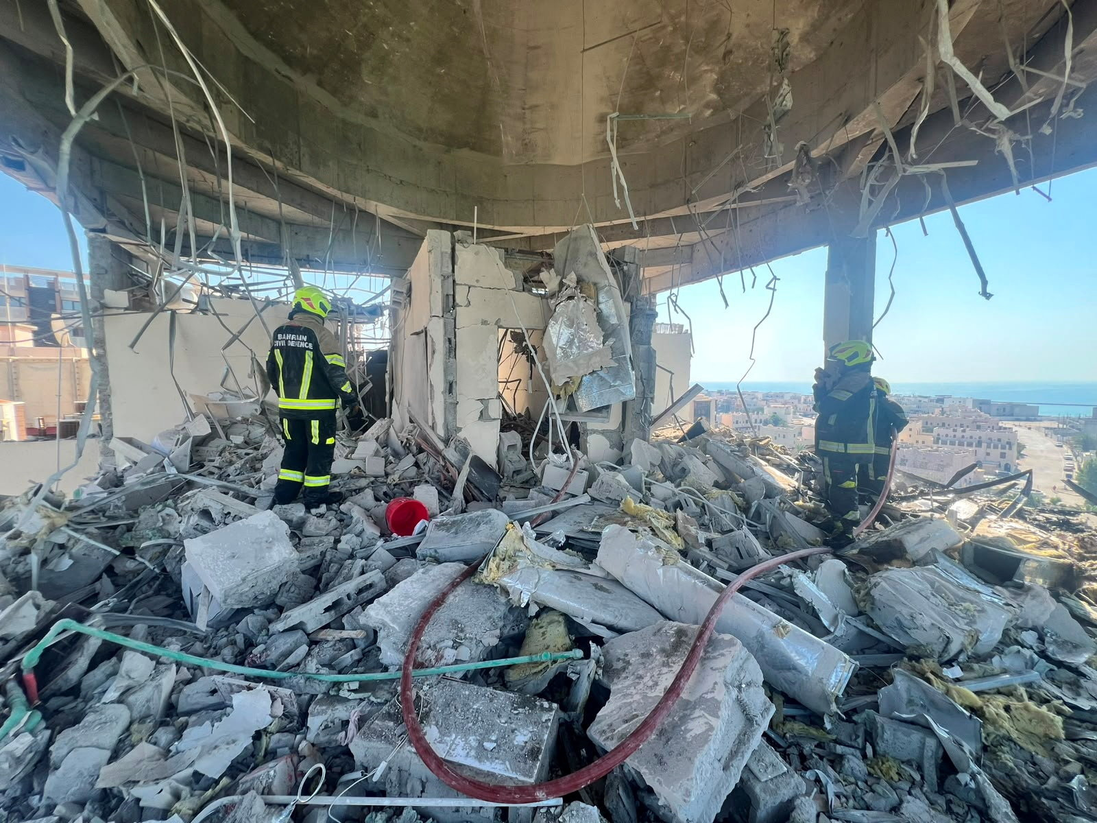 Bahrain civil defence and rescue personnel work in a residential building