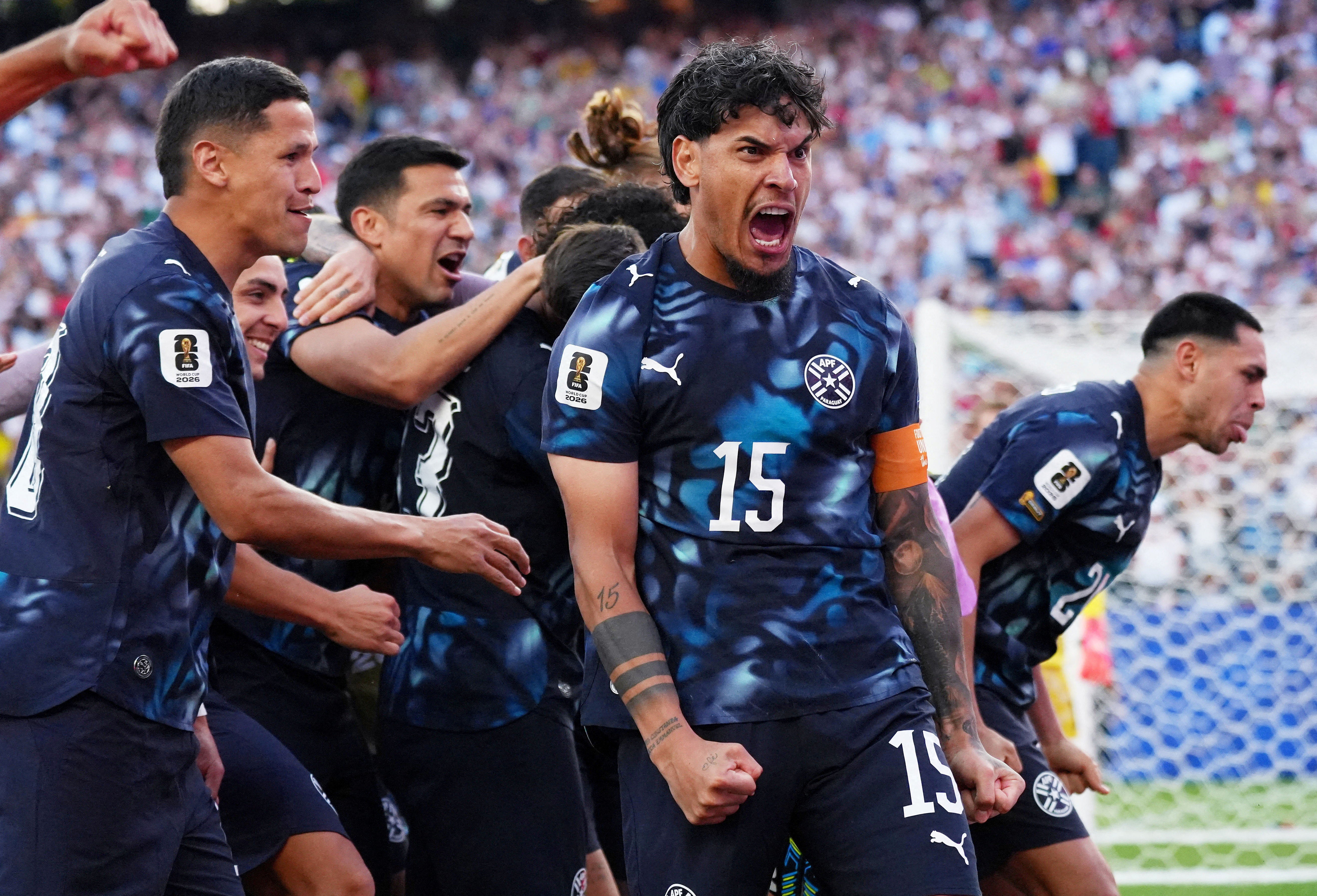 Paraguay's players celebrate together on the pitch after their penalty shootout win over Germany