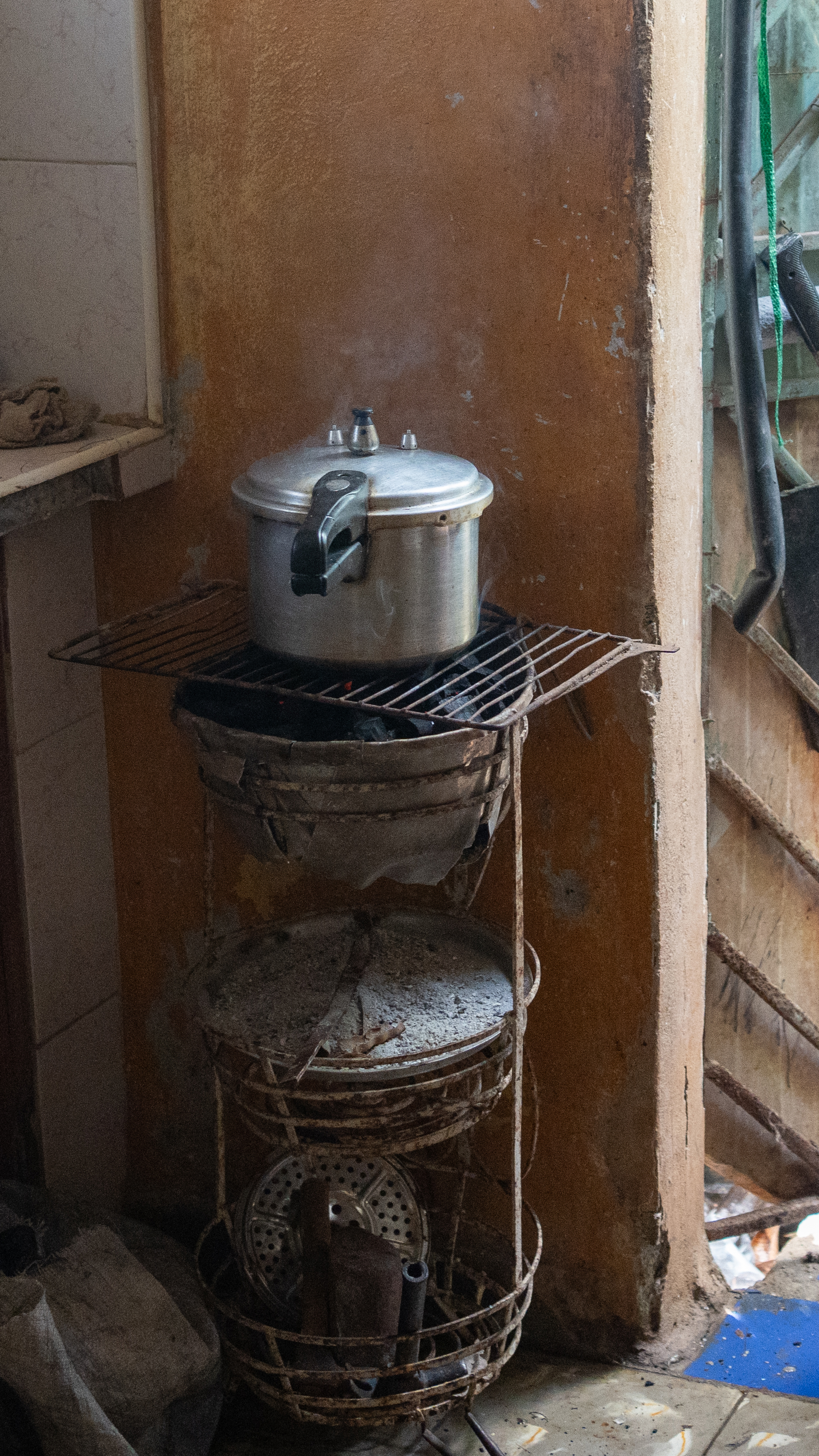 Idalberto Espinoza, 60, cooks chicken over a charcoal stove at his home in Cotorro, on the outskirts of Havana. [Lucien Migne/Al Jazeera]