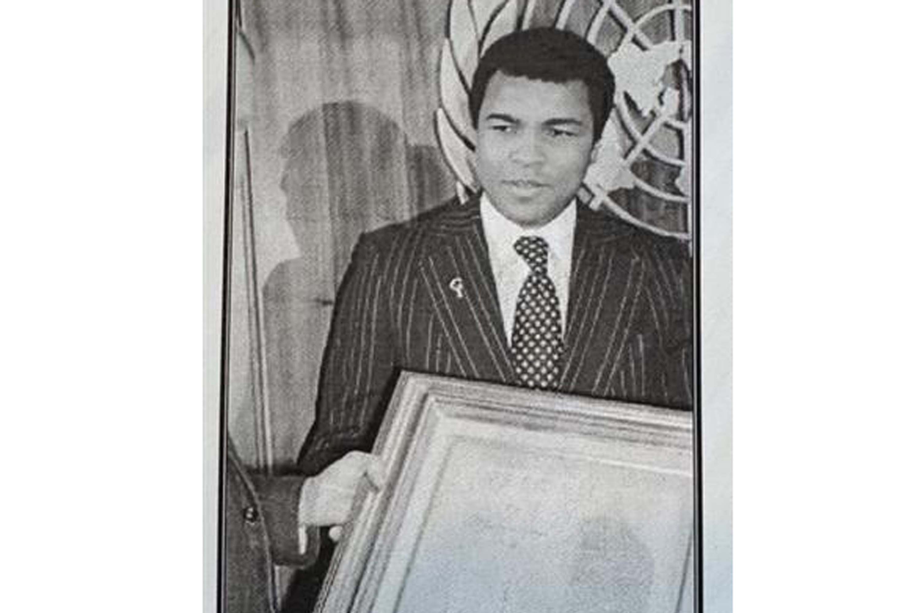 A photo of Muhammad Ali presenting his painting to UN officials in 1978