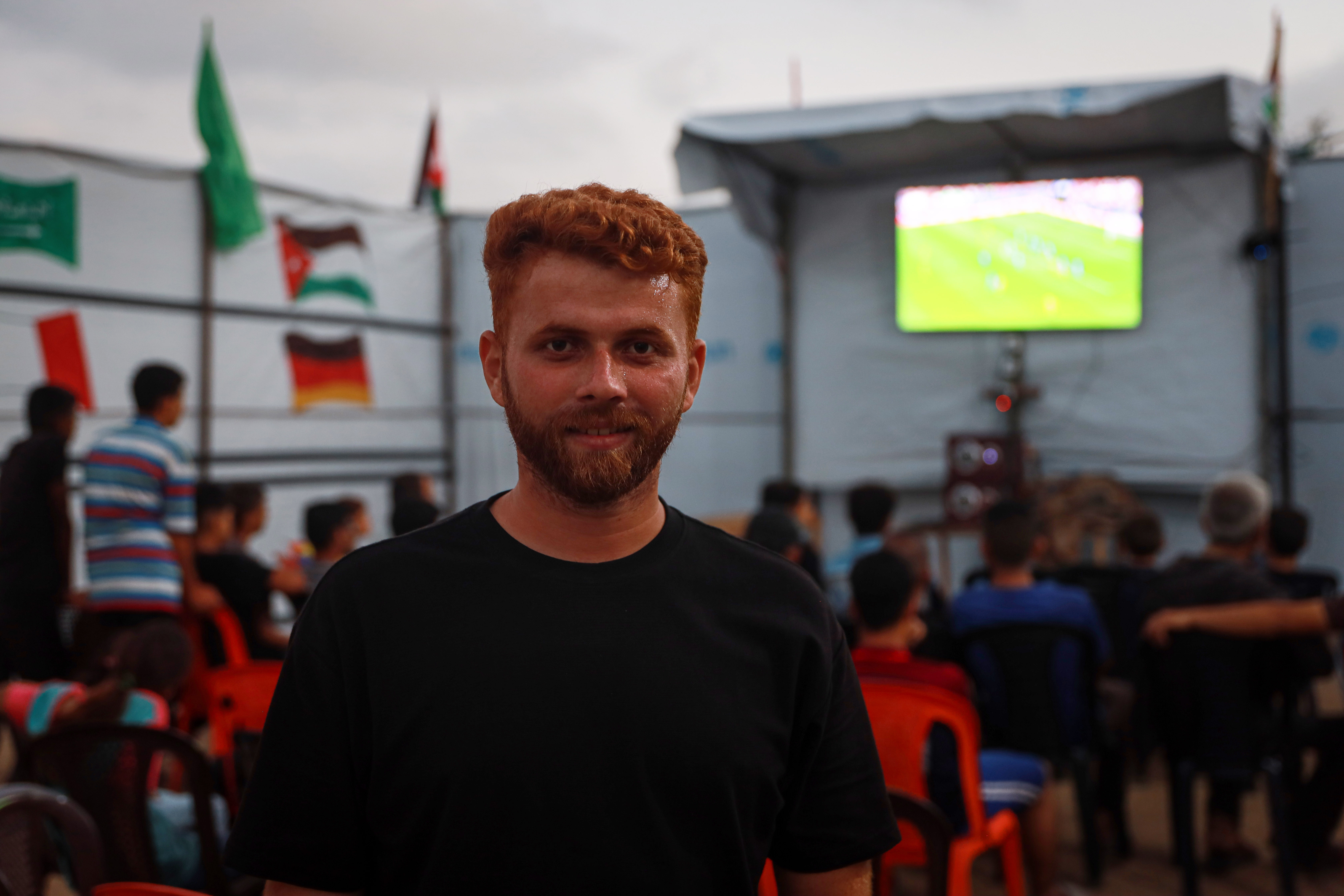 Tareq Al-Jadba set up a makeshift café inside the camp where he lives, allowing displaced residents around him to watch World Cup matches. [Abdelhakim Abu Riash/ Al Jazeera]