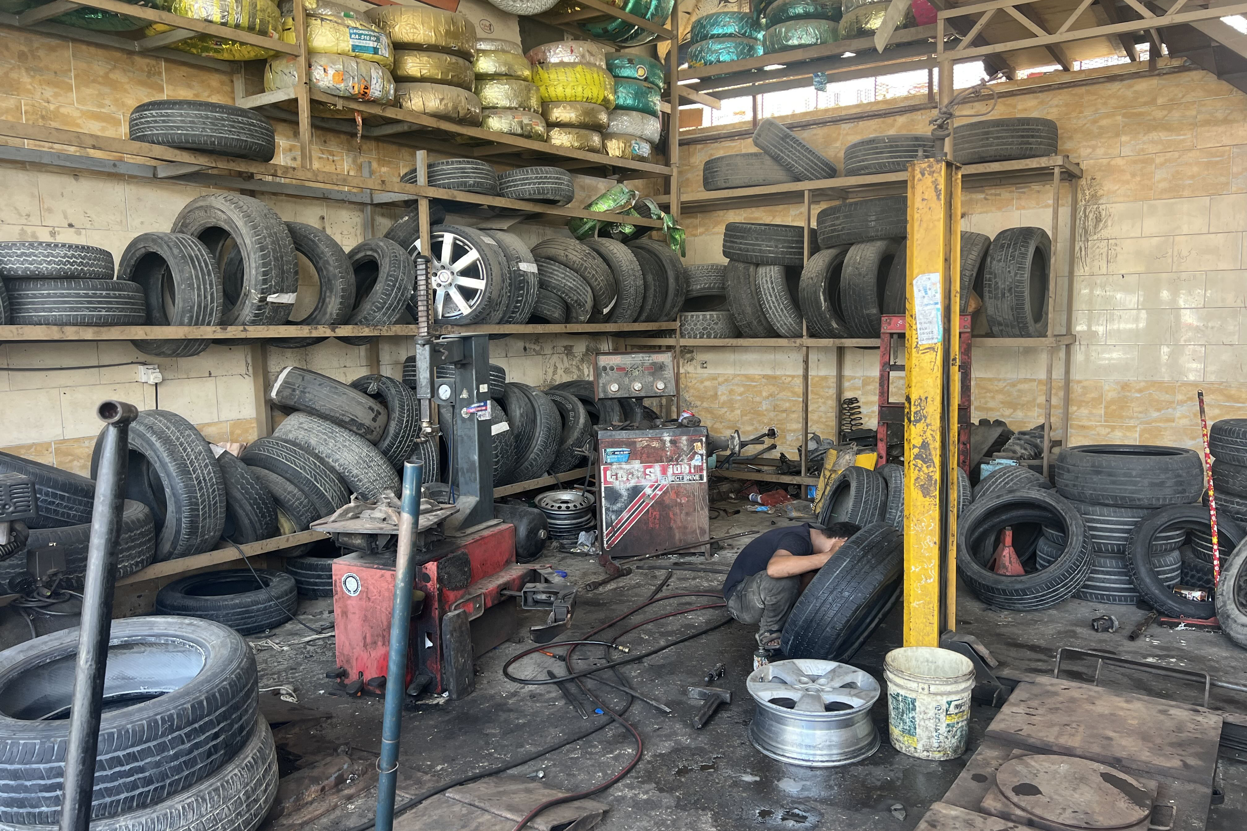A tyre repair worker services a vehicle in Yemen’s city of Mukalla, where prolonged power cuts are hurting businesses, including car repair and maintenance garages.