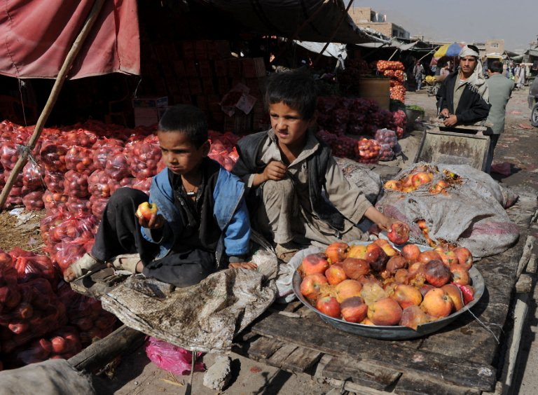 Afghan boys collect rotten apples at the vegetable market in Kabul on October 12, 2010. Afghanistan is one of the world's poorest countries where unemployment is at 40 percent and half the population is under the poverty line. Fruit production levels have increased in recent years but logistical difficulties with packaging and distribution are holding back the Central Asian nation's potential to reach markets beyond it's borders and create a stable industry which can attract foreign buyers. AFP PHOTO/SHAH Marai (Photo by SHAH MARAI / AFP)