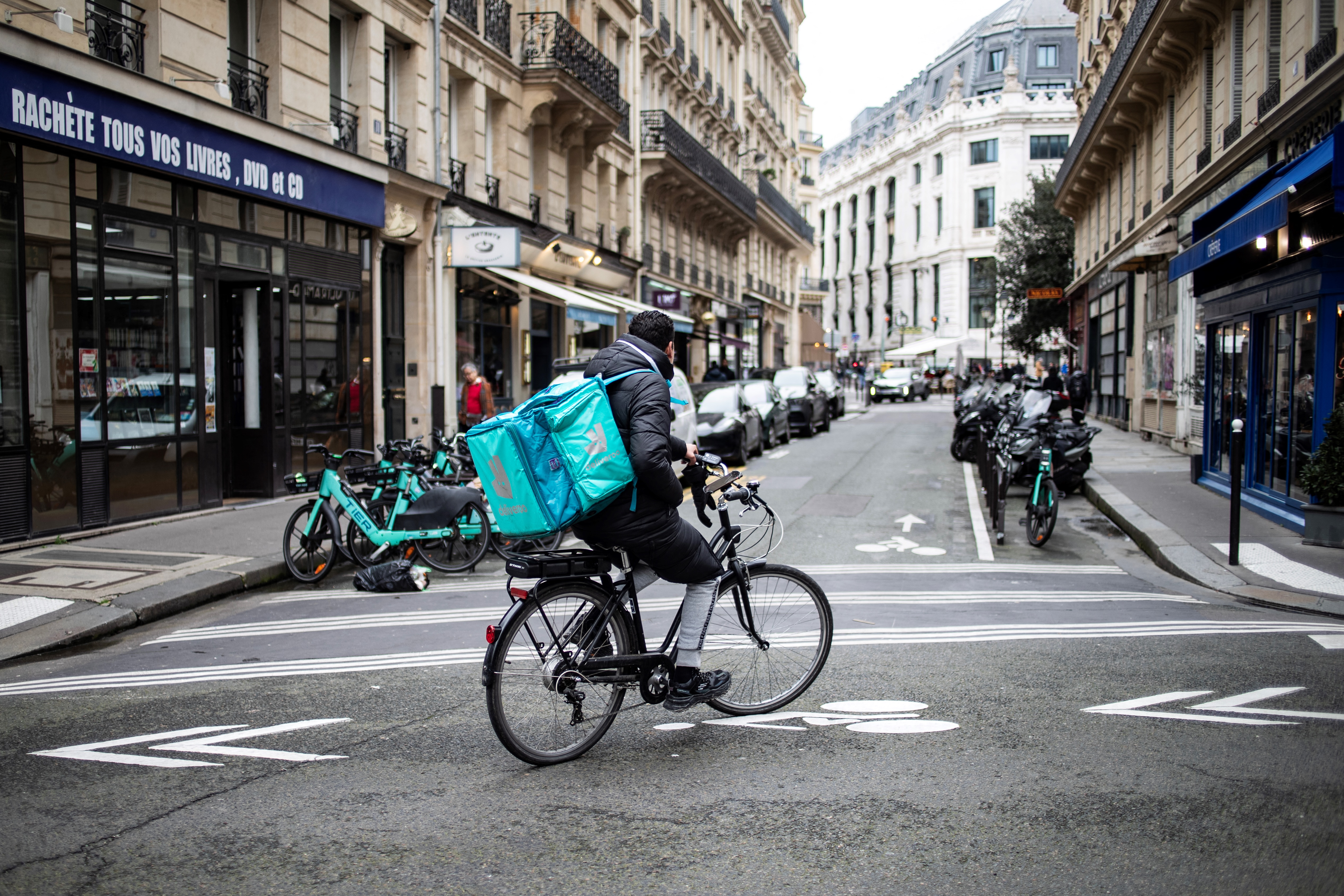 A takeaway delivery driver rides a bike in Paris, France on March 13, 2024.