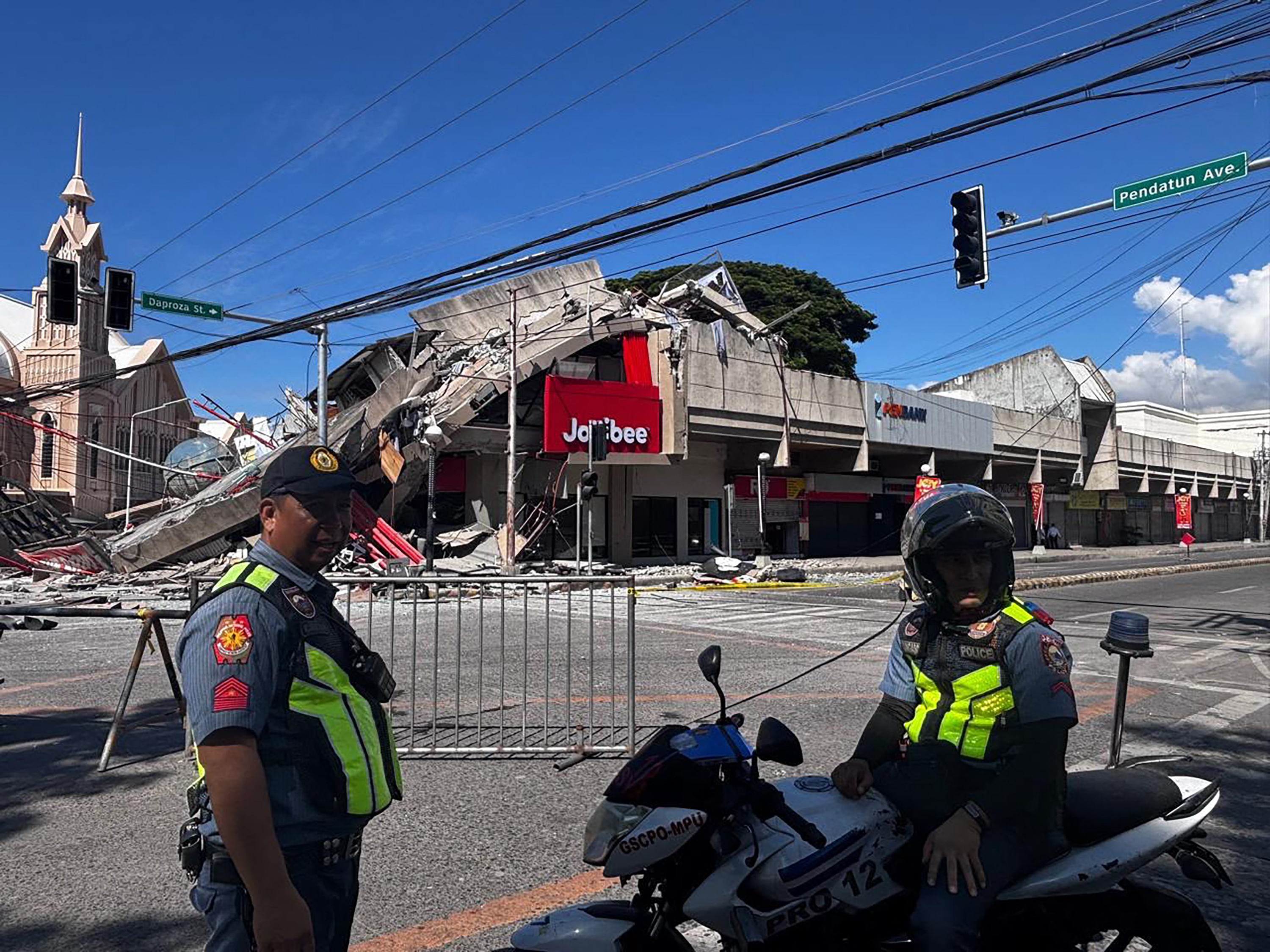 Police gather in front of a collapsed Jollibee fast food restaurant after an 7.8 magnitude earthquake in General Santos City on June 8, 2026. A 7.8-magnitude earthquake that struck the southern Philippines on June 8 killed at least one person and collapsed buildings, police said, as the disaster sparked tsunami warnings across the region. (Photo by Edwin Espejo / AFP)