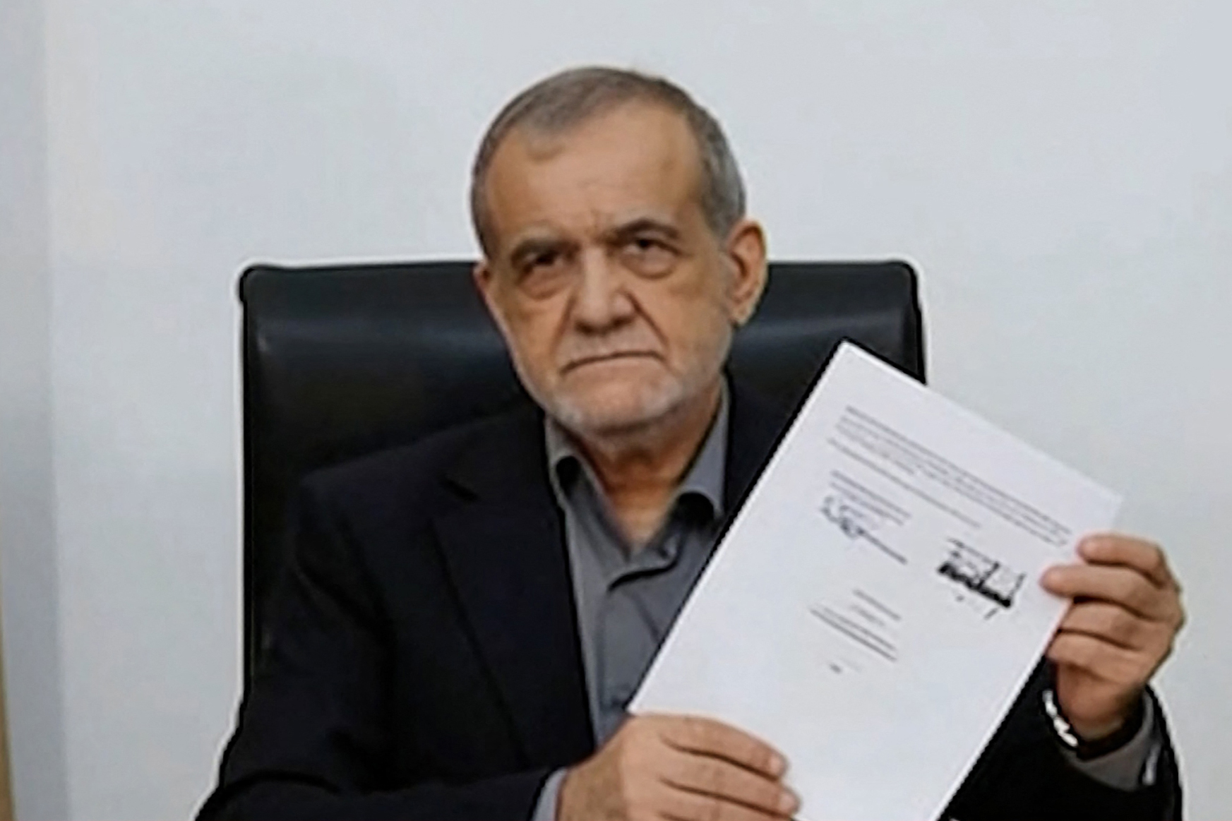 This screen grab taken from video footage broadcast by Iran's IRINN Iranian state television network and made available via AFPTV on June 18, 2026 shows Iran's President Masoud Pezeshkian holding a document showing a memorandum of understanding he signed to end the Middle East war. US President Donald Trump and Iran's president signed a deal on June 17 meant to end the Middle East war, with Tehran agreeing to dilute its enriched uranium in return for large-scale economic relief. (Photo by Handout / various sources / AFP) / - Israel OUT / Israel OUT / NO Access Israel Media/Persian Language TV Stations Outside Iran / Strictly No Access BBC Persian / VOA Persian/Manoto TV / Iran International / / Radio Farda -- / Attention editors: AFP covers the war in the Middle East through its extensive regional network, including bureaus in Tehran, Jerusalem, and several neighboring countries. Since the start of the conflict, journalists have been working under increasingly restrictive conditions. Authorities in several countries have limited reporters' movements, photo and live video coverage from sensitive locations. Some governments and armed groups have banned images of missile or drone strikes and other security-related sites. RESTRICTED TO EDITORIAL USE - MANDATORY CREDIT "AFP PHOTO / IRINN via AFPTV" - HANDOUT - NO MARKETING NO ADVERTISING CAMPAIGNS - DISTRIBUTED AS A SERVICE TO CLIENTS /