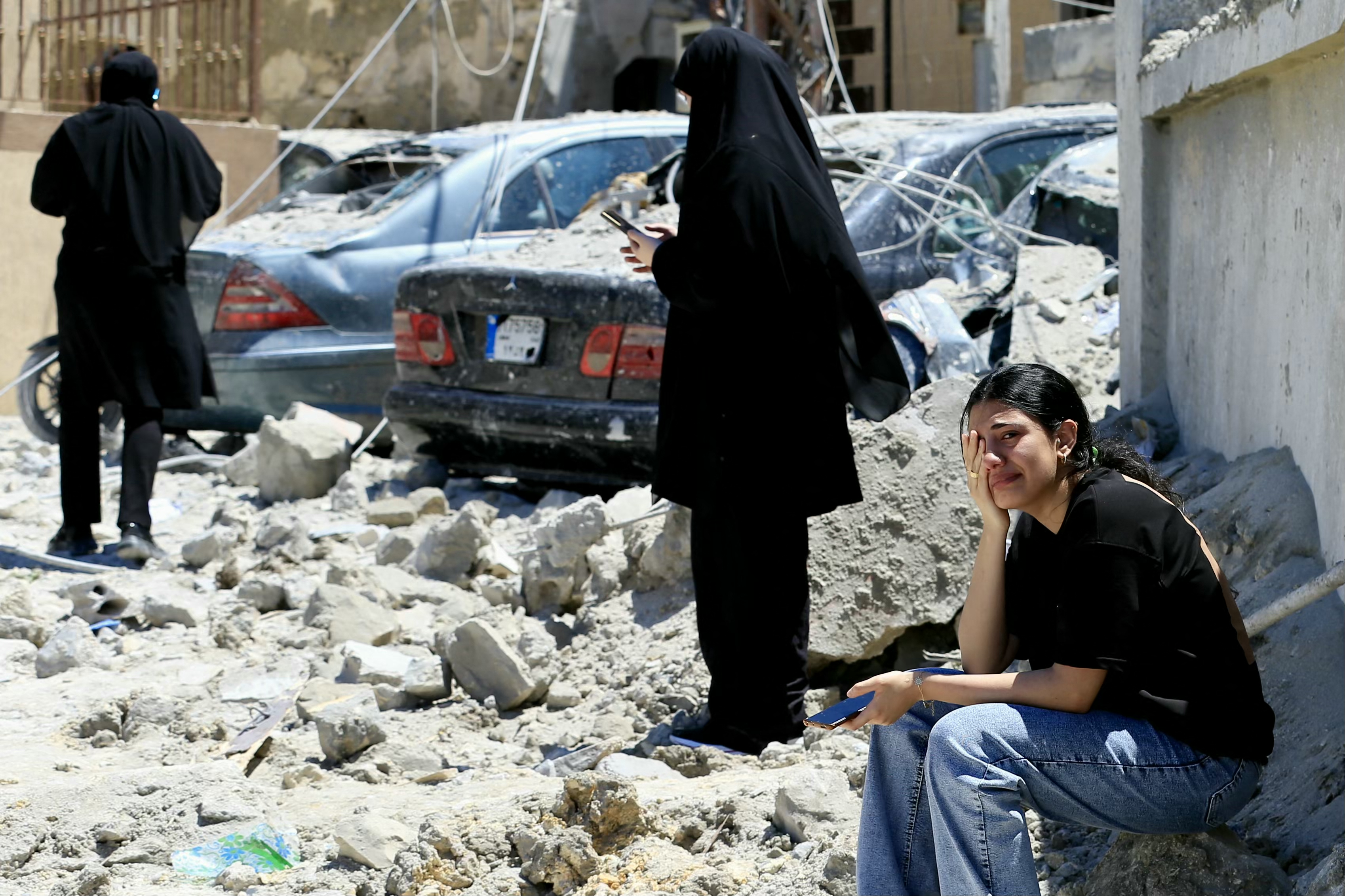 A Lebanese woman weeps as she sits on the rubble at the site of an Israeli airstrike that targeted the southern Lebanese village of Qennarit on June 20, 2026. Israel carried out deadly strikes in south Lebanon on June 20, and Hezbollah maintained it had the right to respond, hours after the United States announced a renewed ceasefire in fighting that had strained a fledgling deal with Iran. Lebanon was drawn into the Middle East war on March 2 when Tehran-backed militant group Hezbollah launched attacks on Israel to avenge the killing of the Iranian leader. Israel has responded with broad strikes across Lebanon and a ground offensive. (Photo by AFP) /