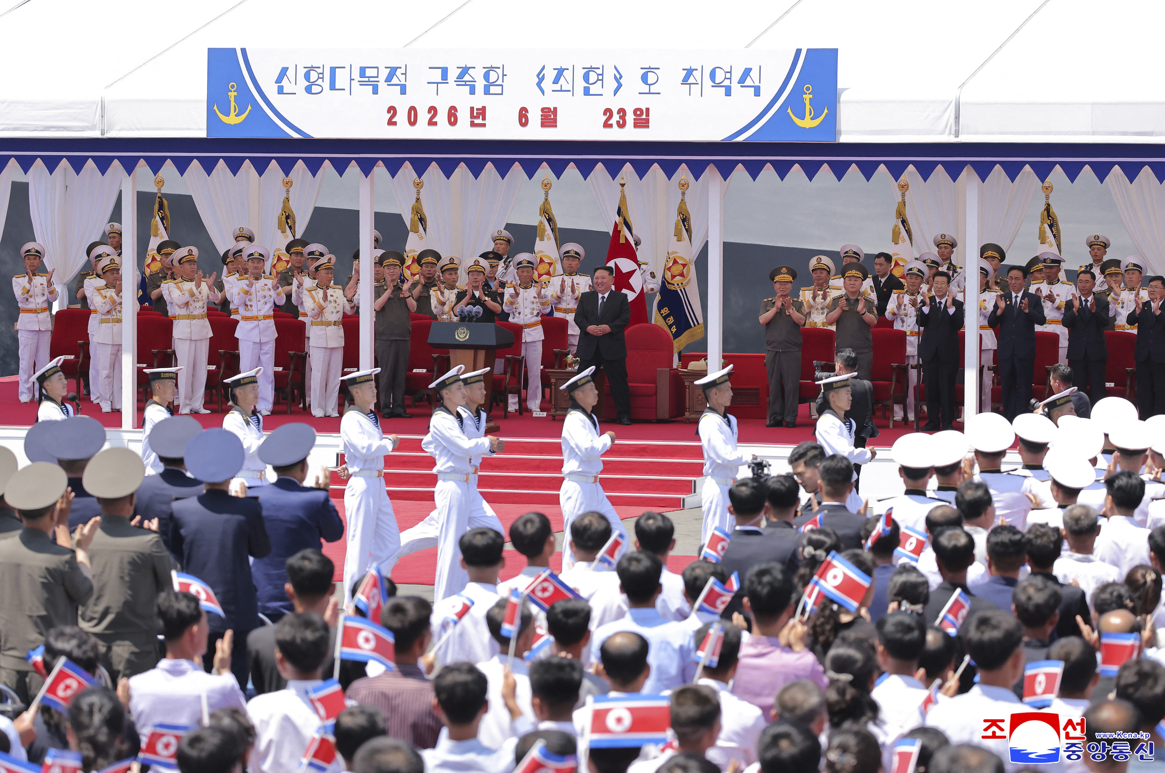 North Korean leader Kim Jong Un attends a naval commissioning ceremony, with military officials nearby.