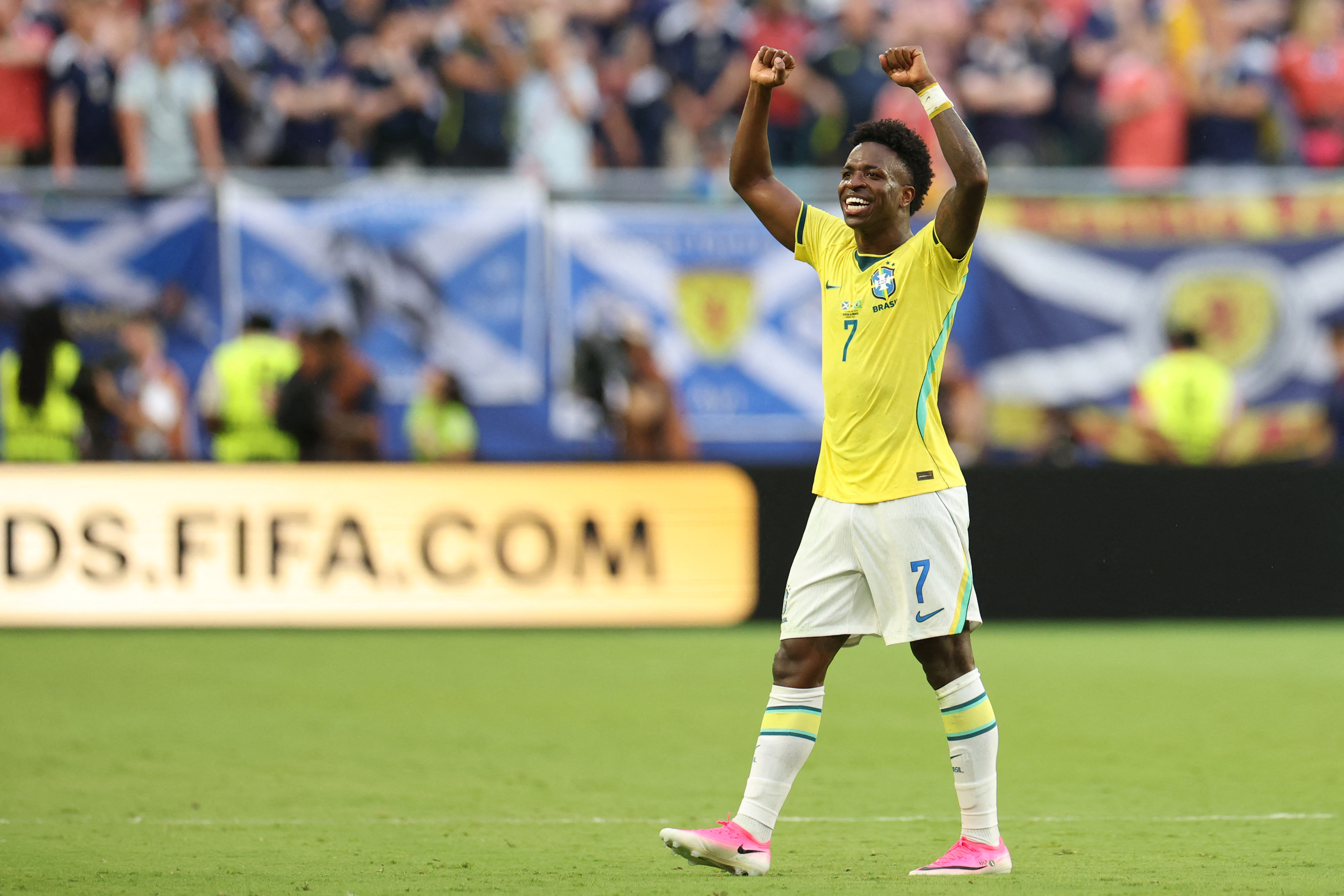 Vinicius Jr runs with his arms spread wide in celebration after scoring