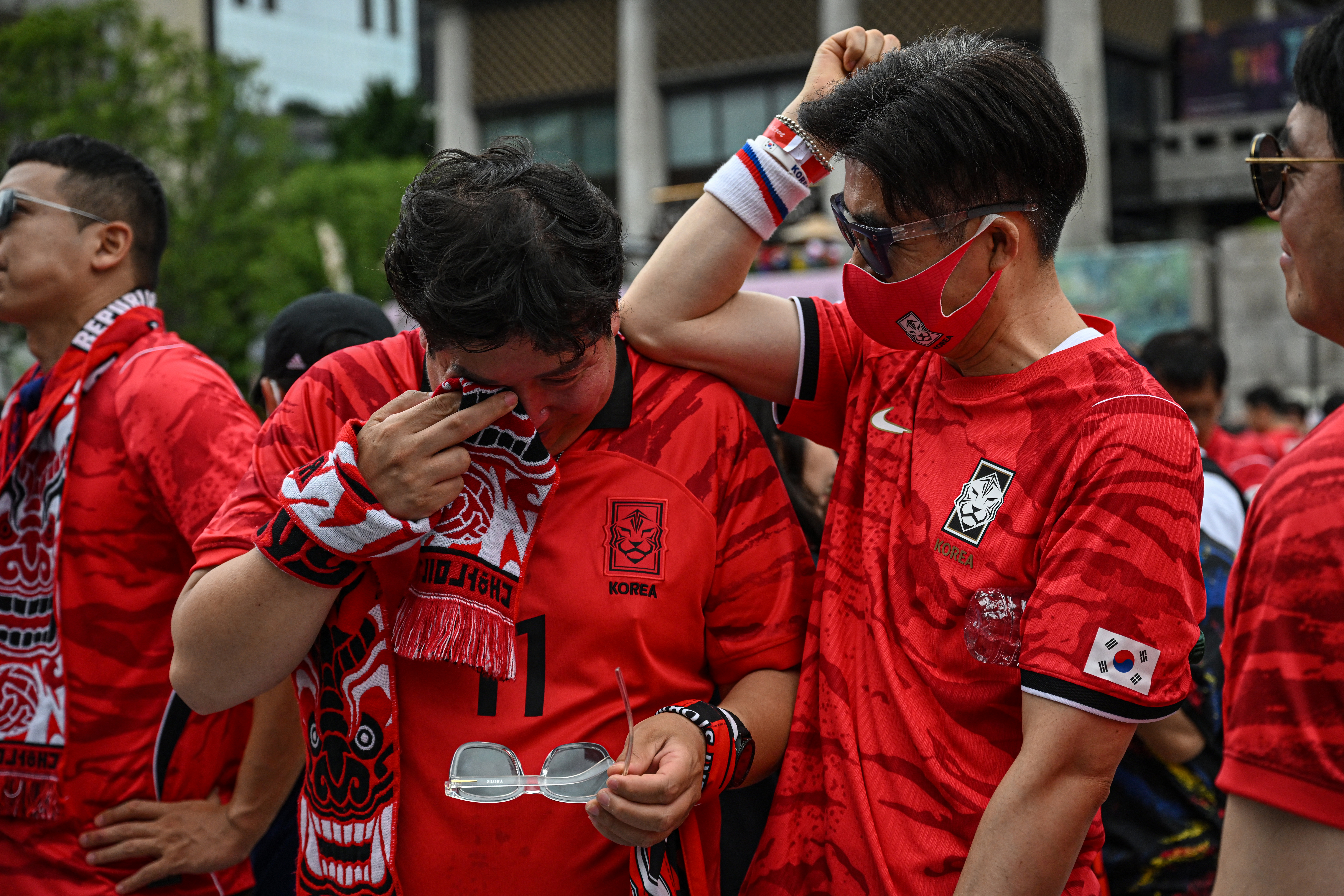 South Korean fans react after their team lost the 2026 World Cup football match against South Africa at Gwanghwamun Square in Seoul on June 25, 2026. (Photo by Jade GAO / AFP)