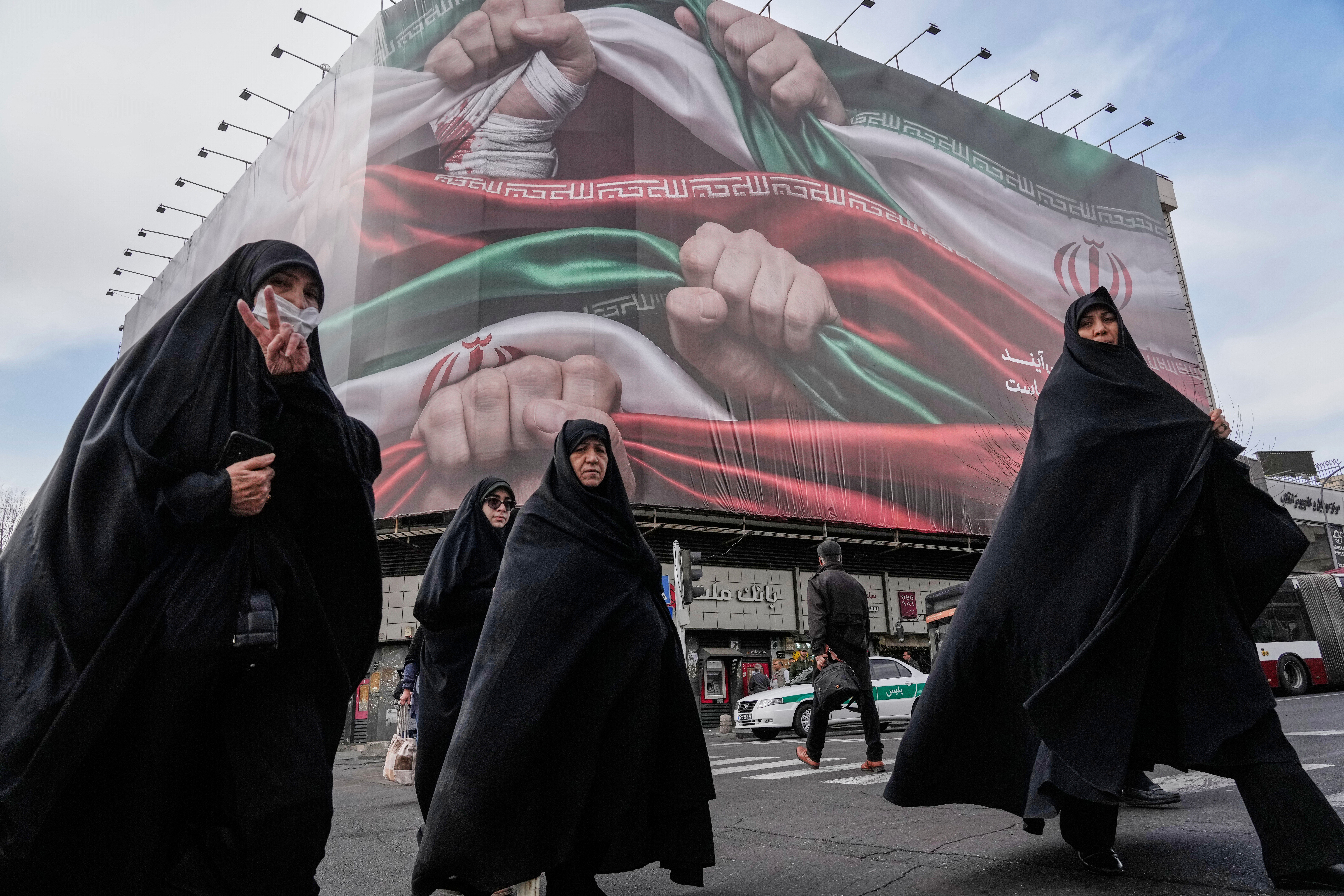 A banner in Tehran showing hands firmly holding Iranian flags as a sign of patriotism, Jan. 14, 2026