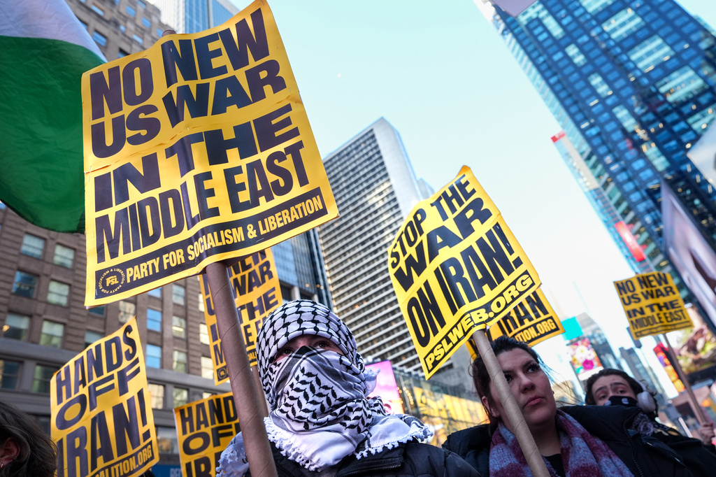 Protesters hows signs against war with Iran