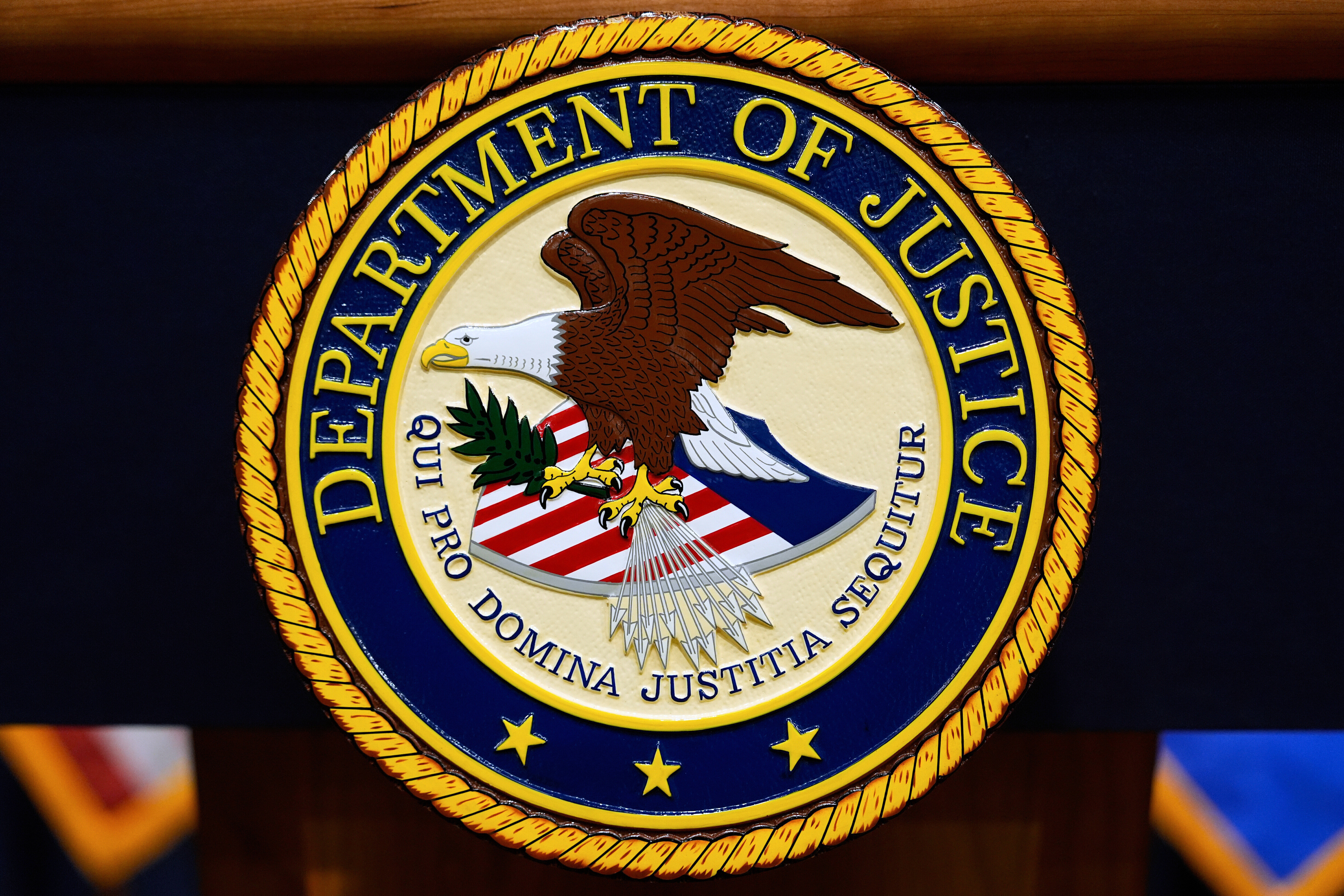 US Department of Justice logo is seen on a podium.