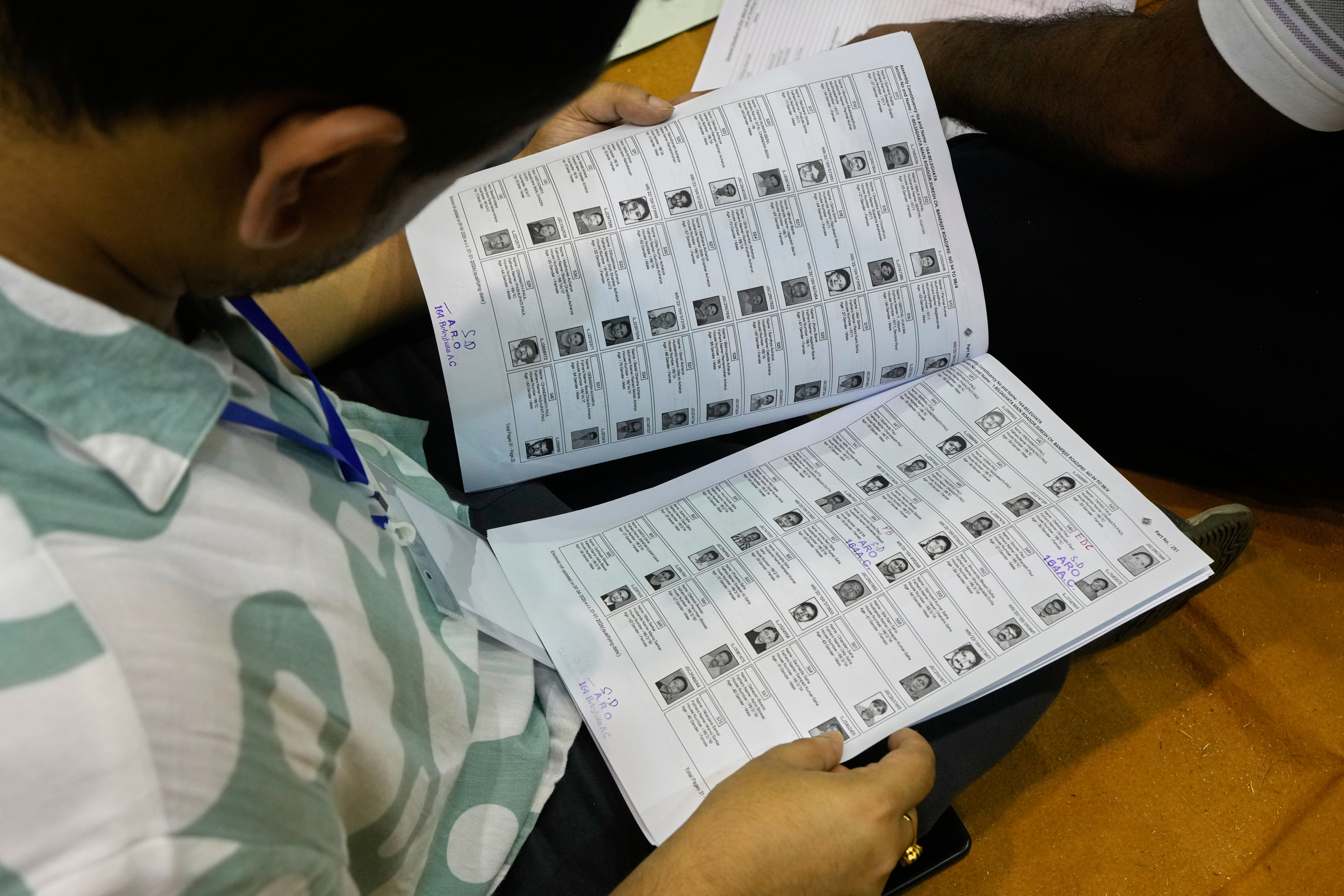 A person checks a voter list.