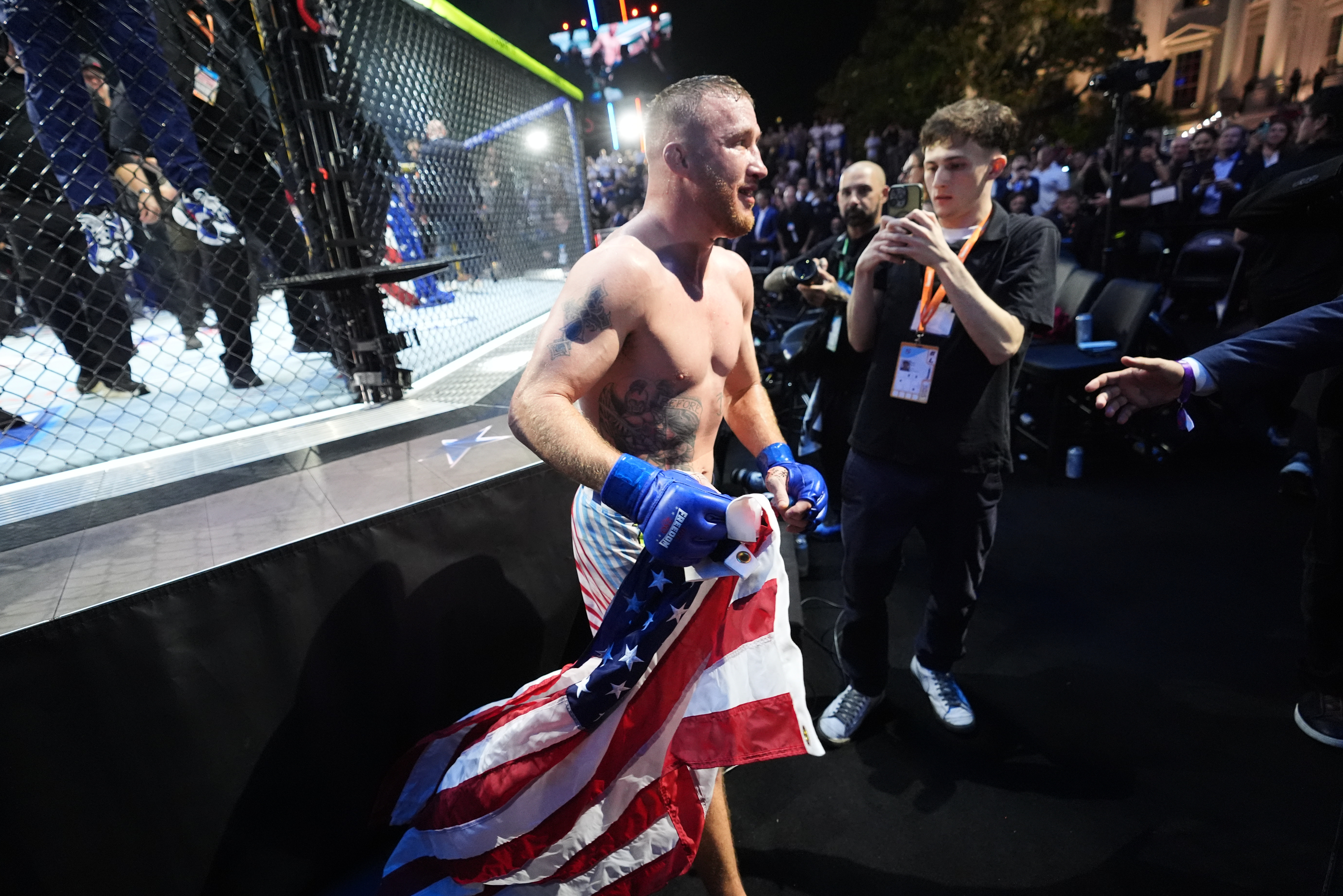 Justin Gaethje celebrates as he holds a US flag.