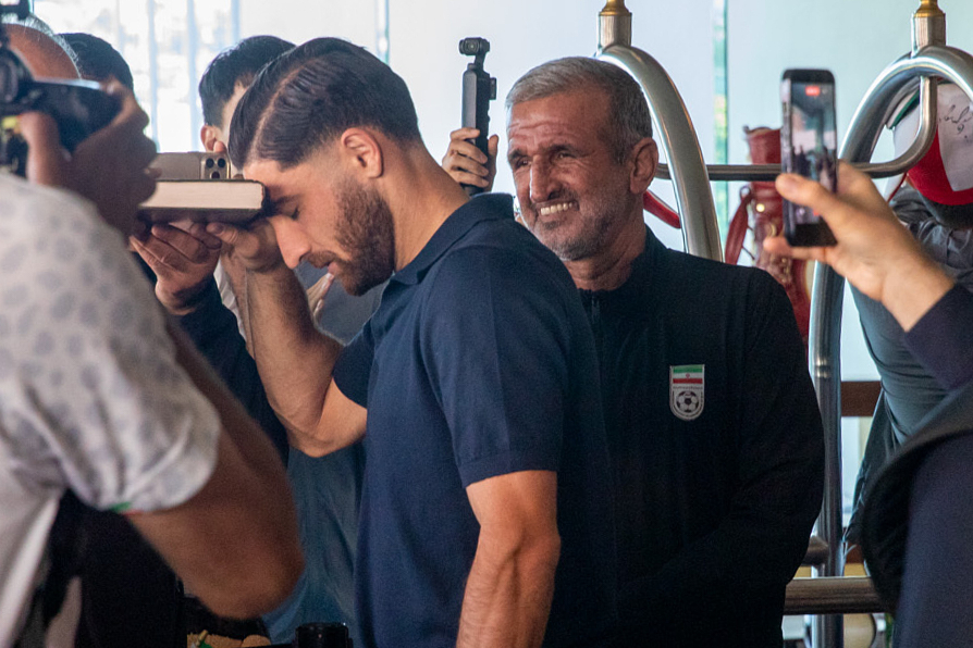 Iran national soccer team member Alireza Jahanbakhsh touches his forehead to the Quran as he departs from the Tijuana Marriott in Tijuana, Mexico on Saturday June 20, 2026. (AP Photo/Gabriela Aoun Angueira)