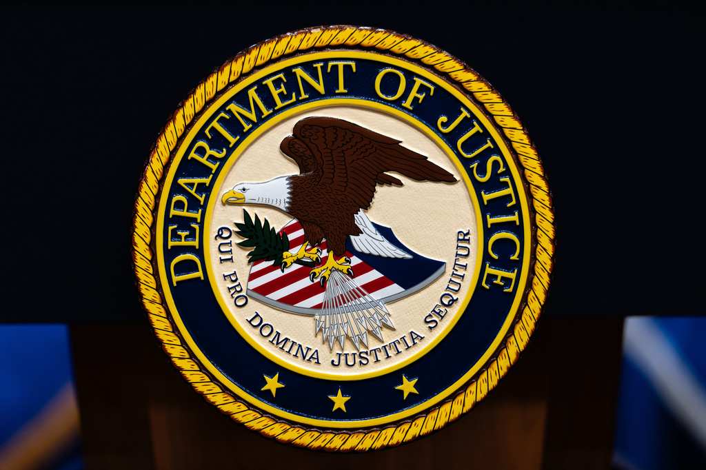 the DOJ logo on a podium