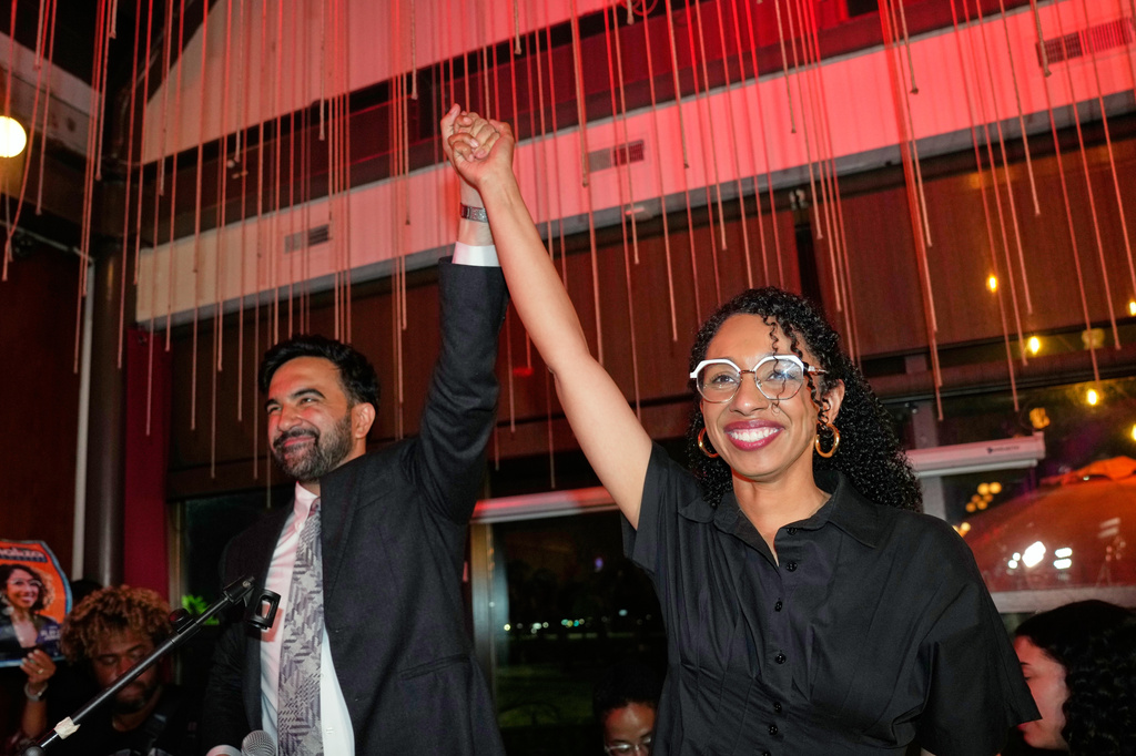Mamdani and Darializa Avila Chevalier raise their hands