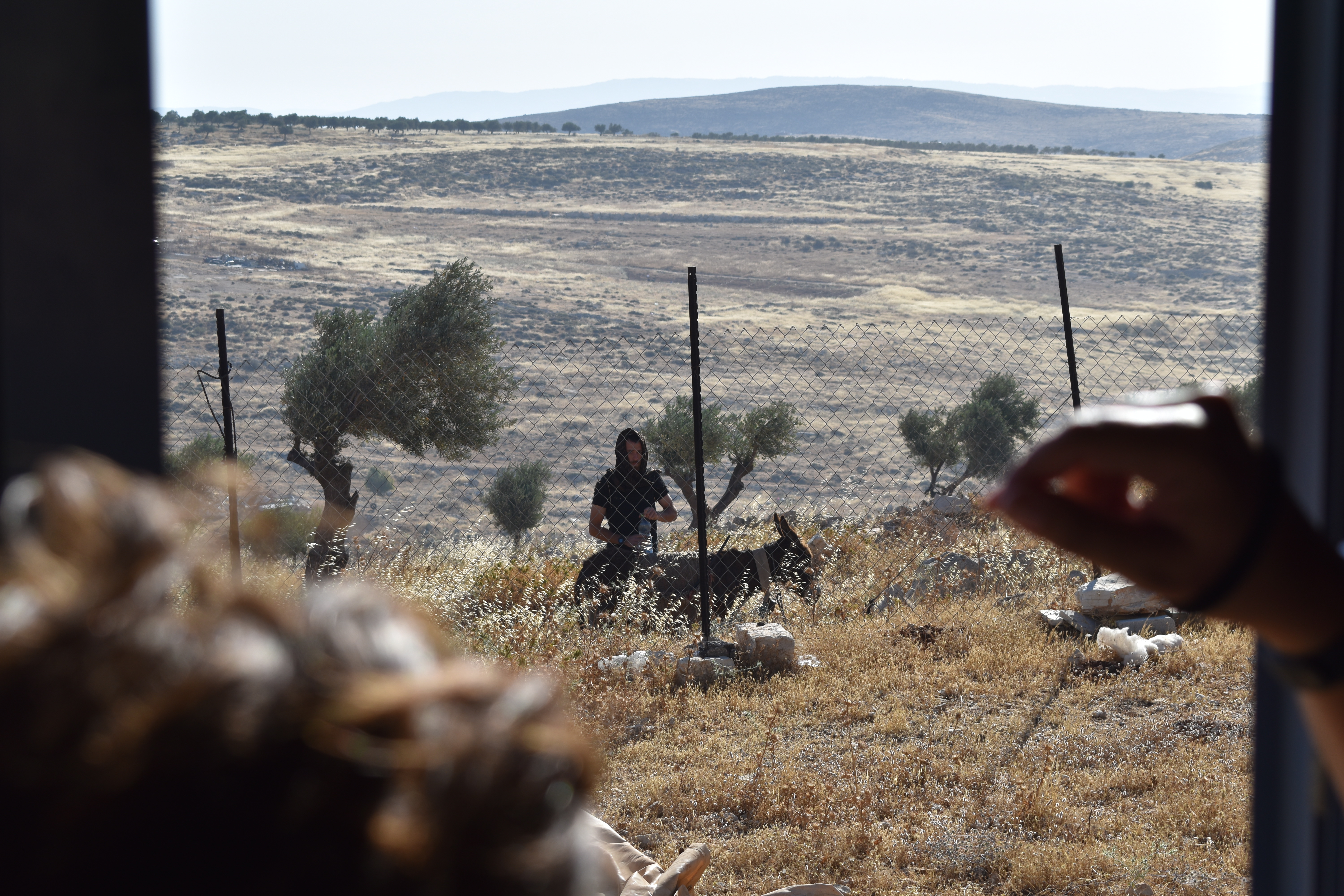 Family hides inside home watching settlers outside fence in Taybeh Junction