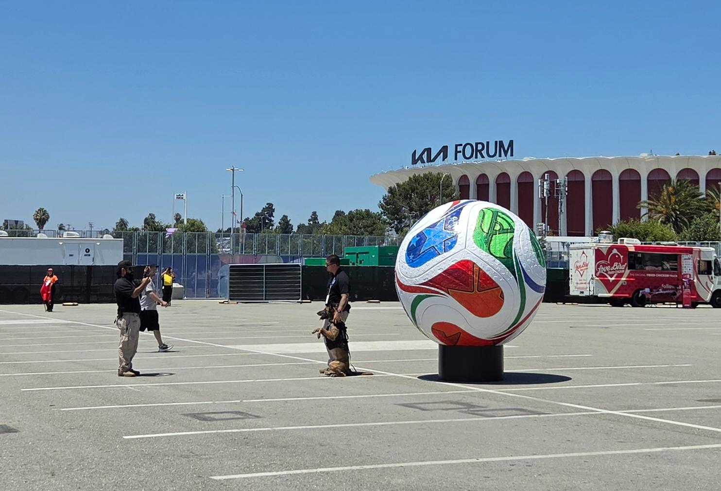 Dog and officer standing next to giant ball