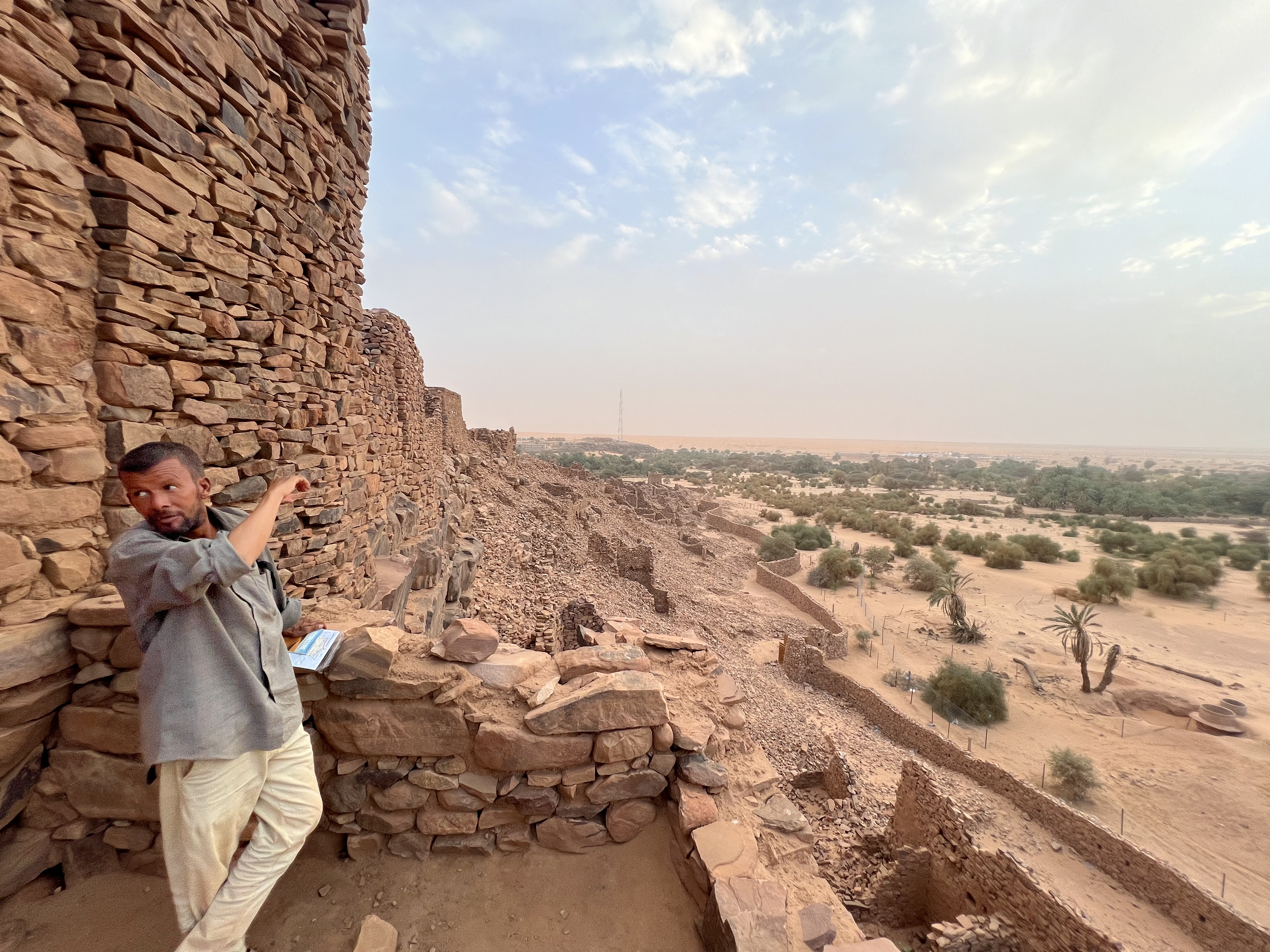 A tour guide points at the crumbling walls of the ruins of the ancient Ouadane, a fort town that prospered during the Trans-Saharan trade between the eighth and 17th centuries