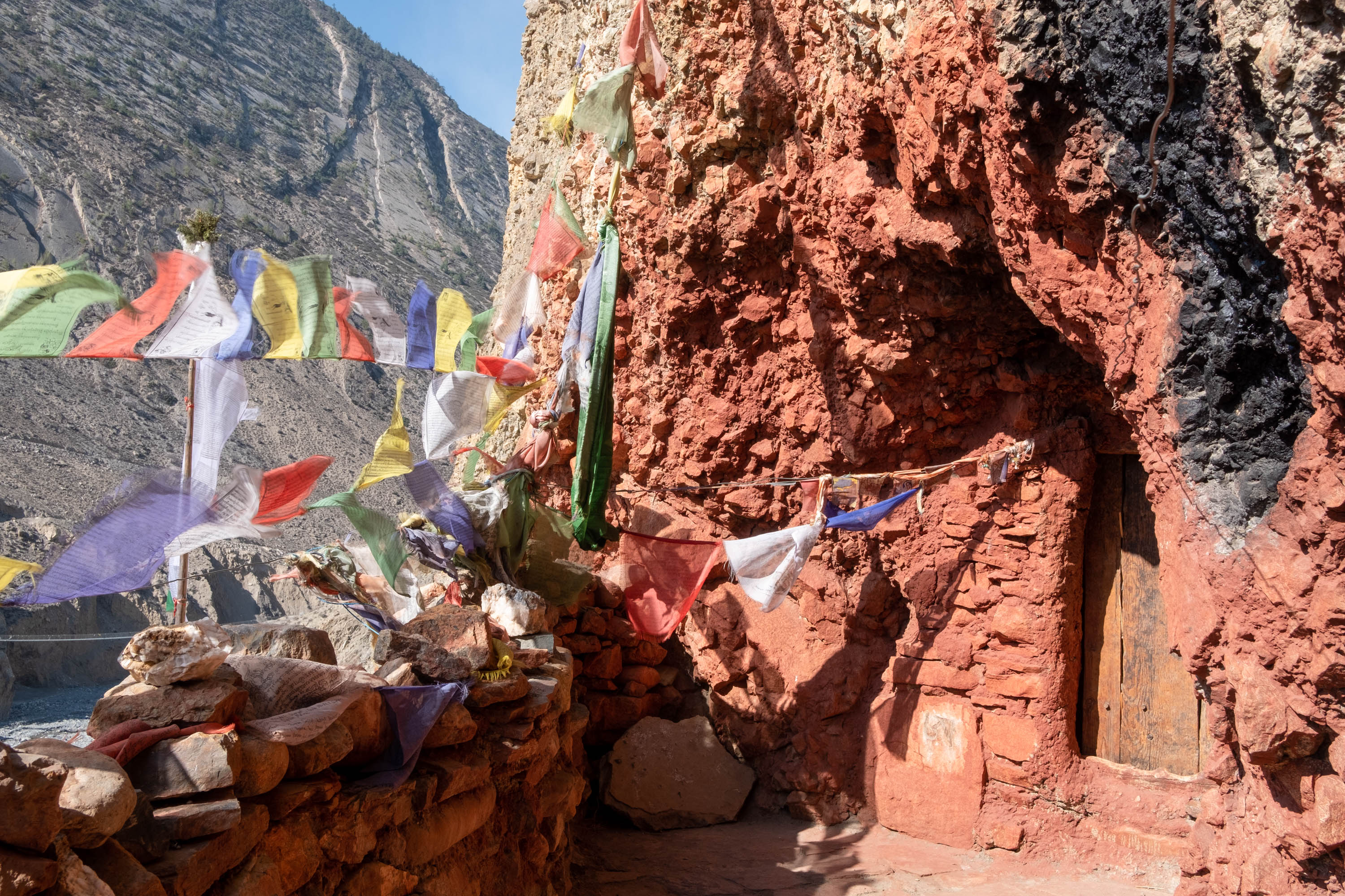 Meditation caves like this one, which are carved into the soft clay cliffs on the opposite side of the valley from Lubra, are also at risk [Eileen McDougall/Al Jazeera]