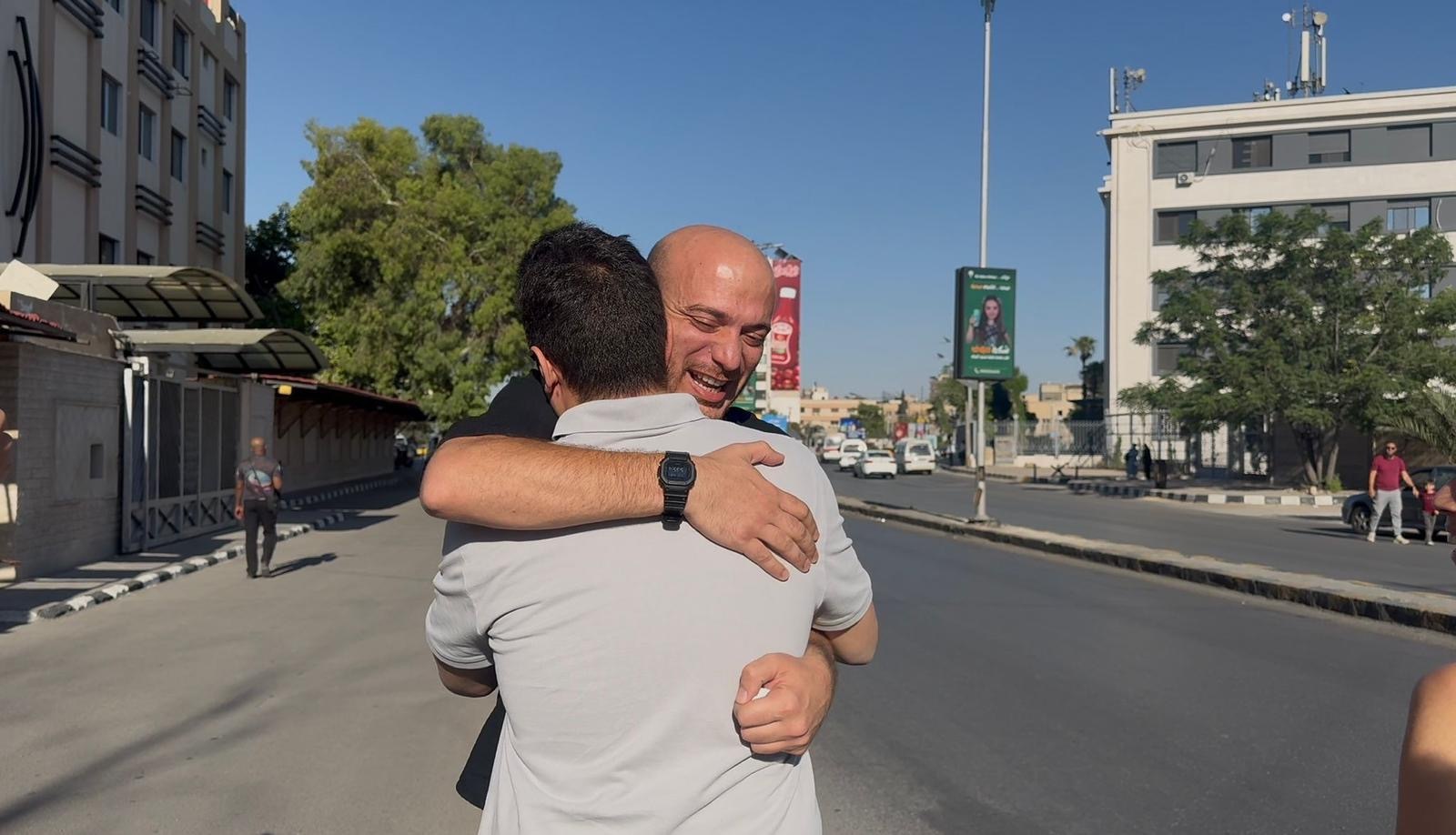 British Syrian activist Hassan Akkad embraces a supporter after his release from detention, in an image provided by his "Give Us the Money That You Owe!" campaign [Handout/Al Jazeera]