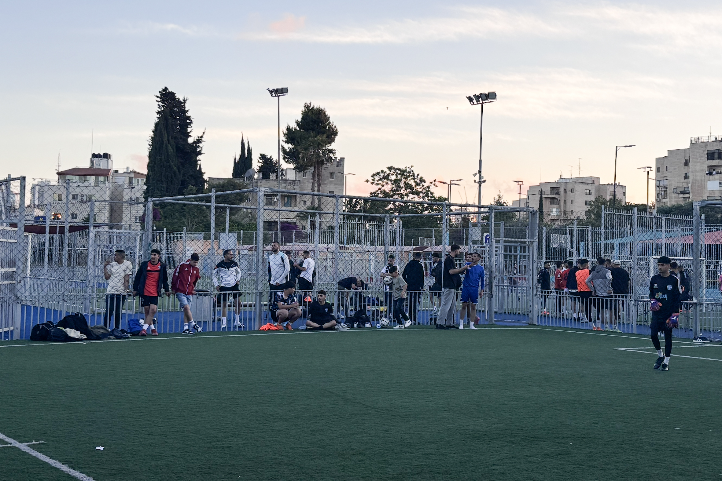 Sunset shot of various people including national team players waiting to play during Eid tournament.