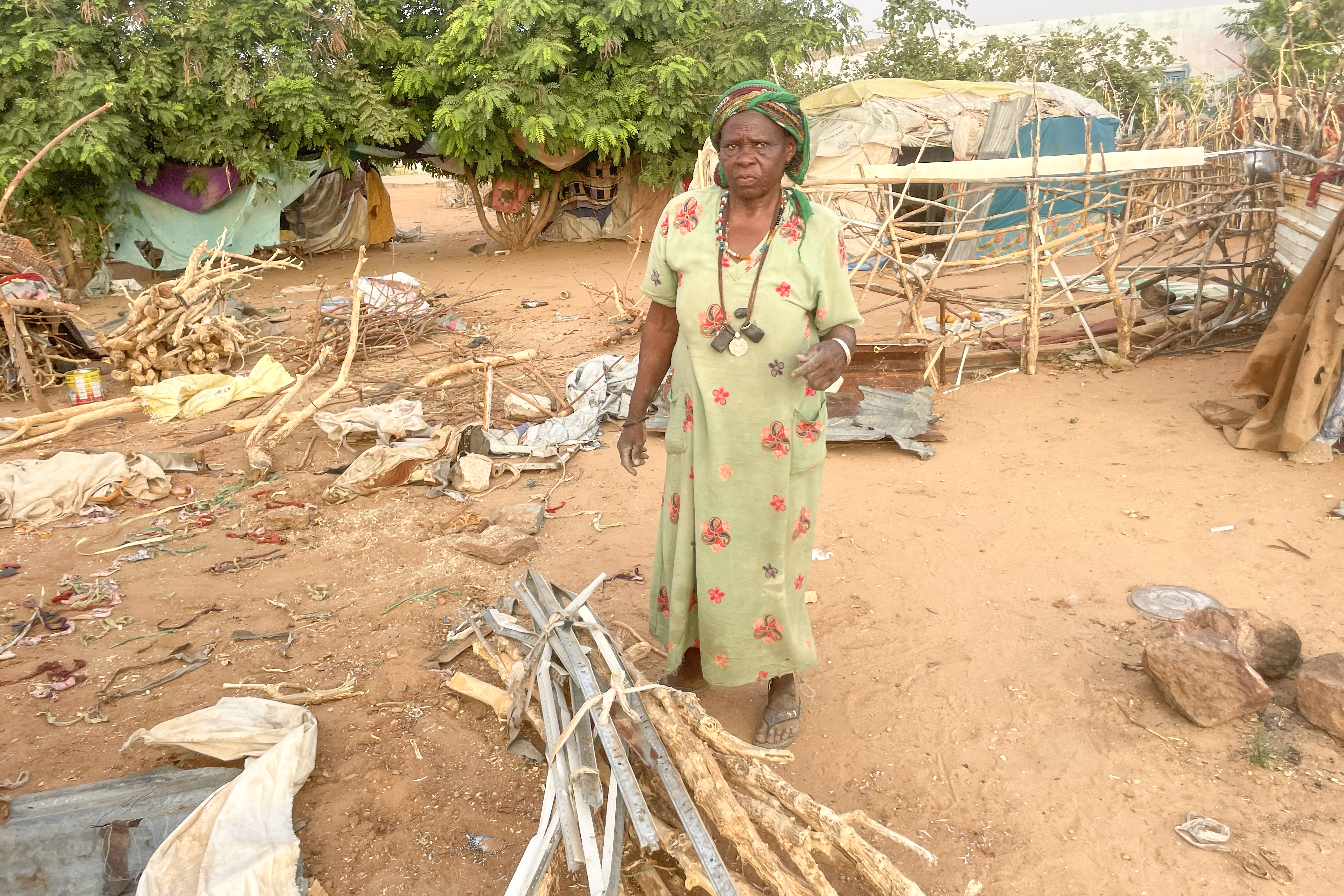 A displaced woman collecting firewood for cooking in el-Geneina [Al Jazeera]