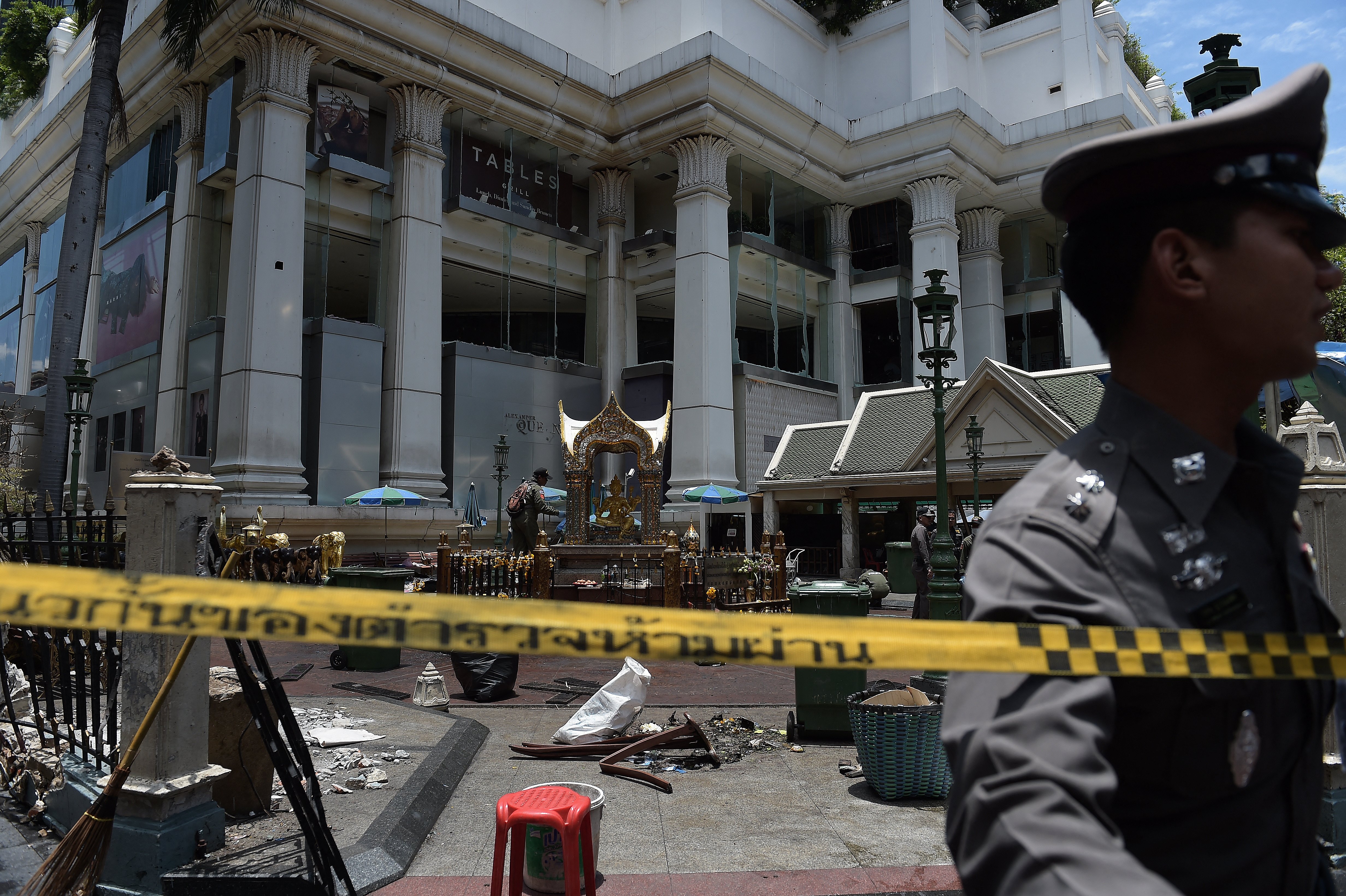 (FILES) A policeman (C) inspects the cordoned-off site of a bomb blast at the Erawan shrine in Bangkok on August 18, 2015.