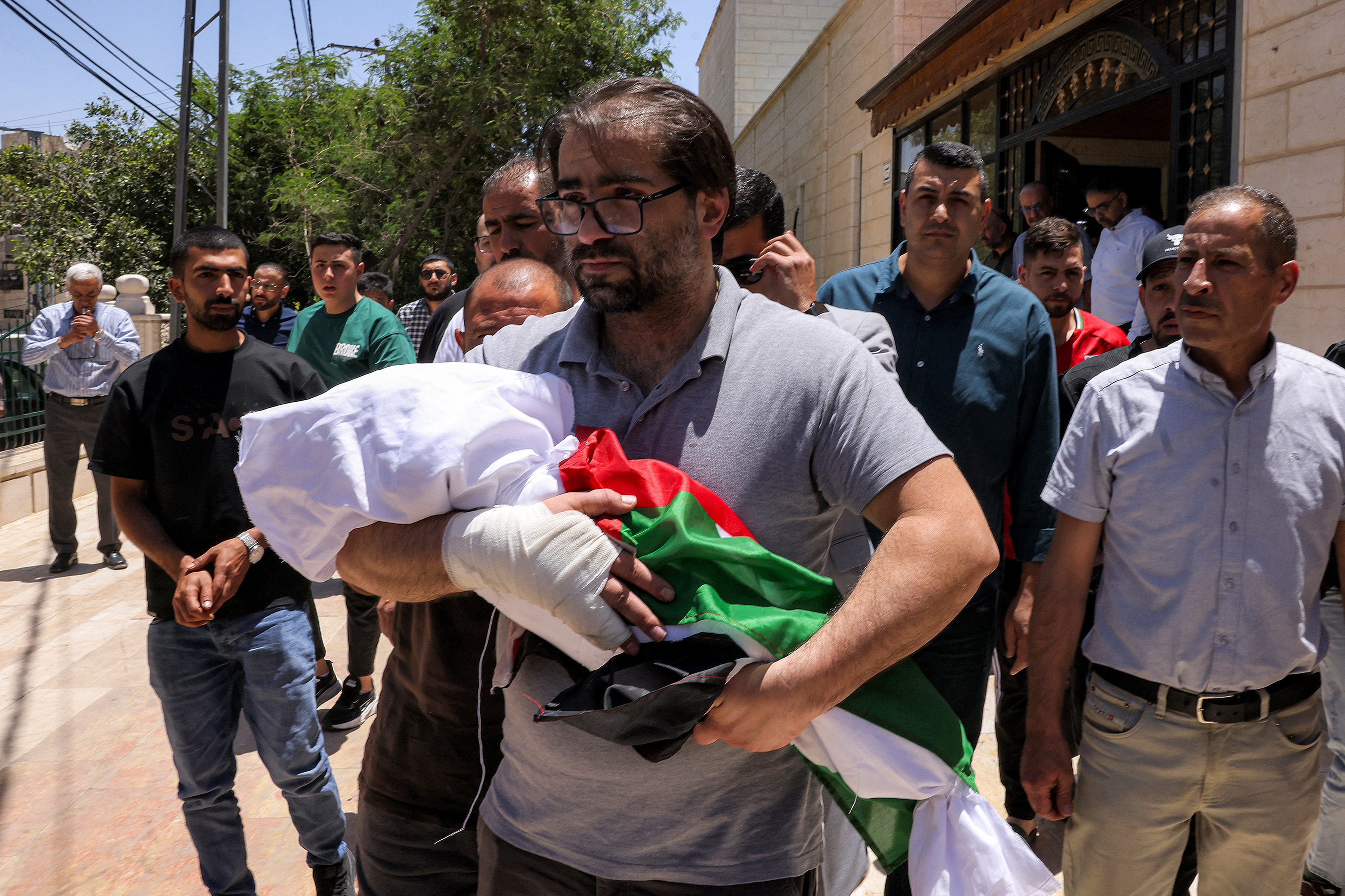 EDITORS NOTE: Graphic content / Palestinian Fahd Abou Haikal carries the body of his seven-month-old son Sam during the funeral in Hebron in the occupied West Bank on June 6, 2026.