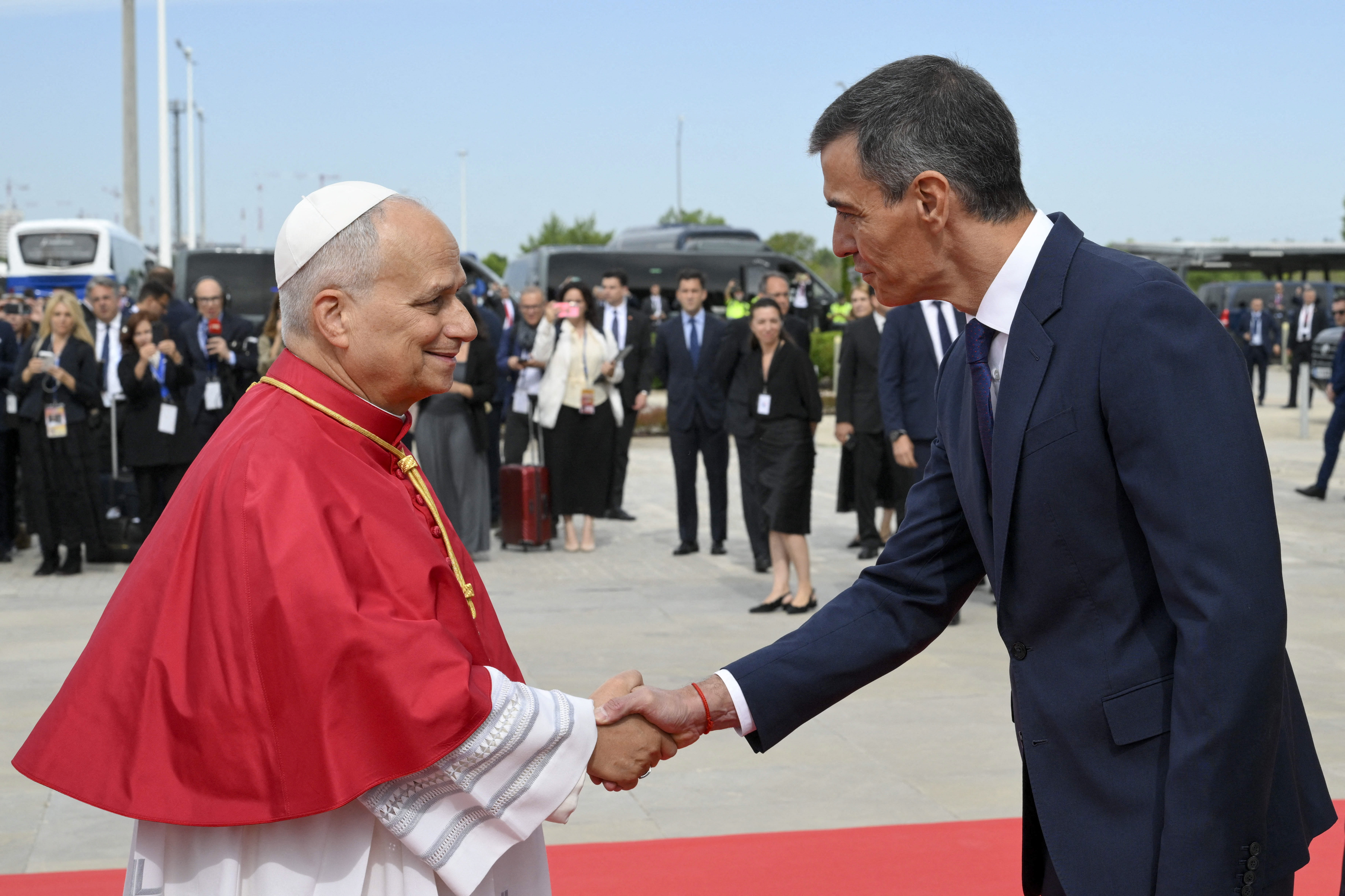 This handout photo taken and released on June 6, 2026 by The Vatican Media shows Spain' Prime Minister Pedro Sanchez welcoming Pope Leo XIV upon his arrival at the Barajas Airport in Madrid.